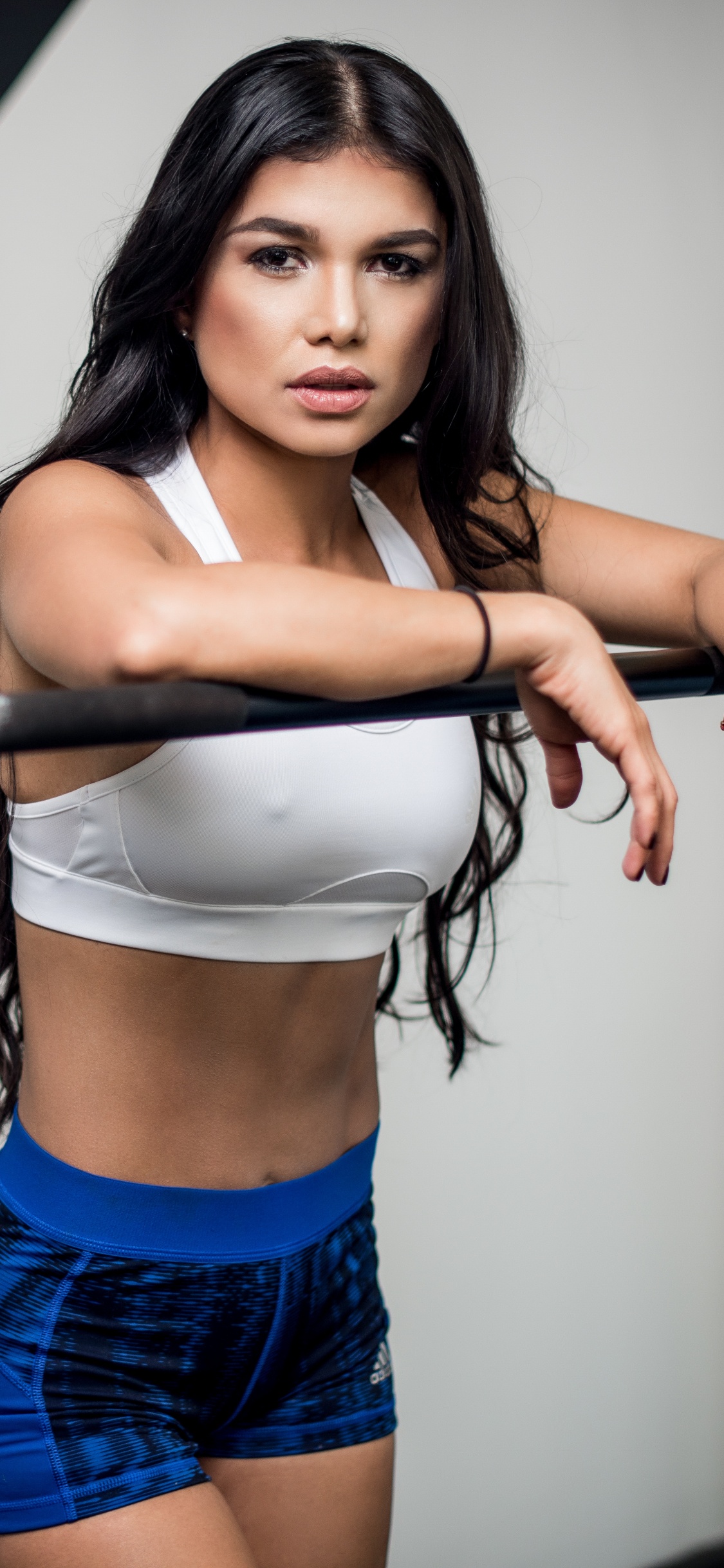 Woman in Blue Denim Shorts Holding Black Dumbbell. Wallpaper in 1125x2436 Resolution