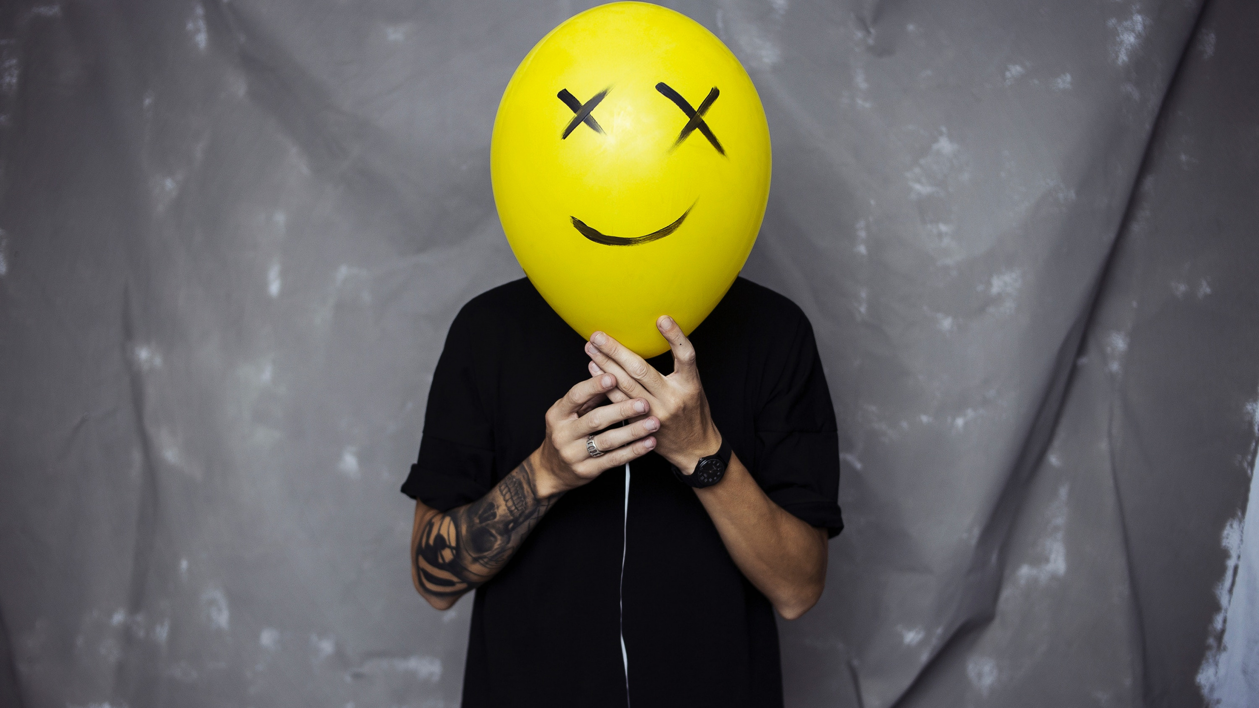 Man in Black T-shirt Holding Yellow Balloon. Wallpaper in 2560x1440 Resolution