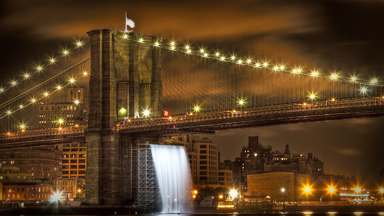 Puente Iluminado Cerca de Los Edificios de la Ciudad Durante la Noche.. Wallpaper in 1280x720 Resolution