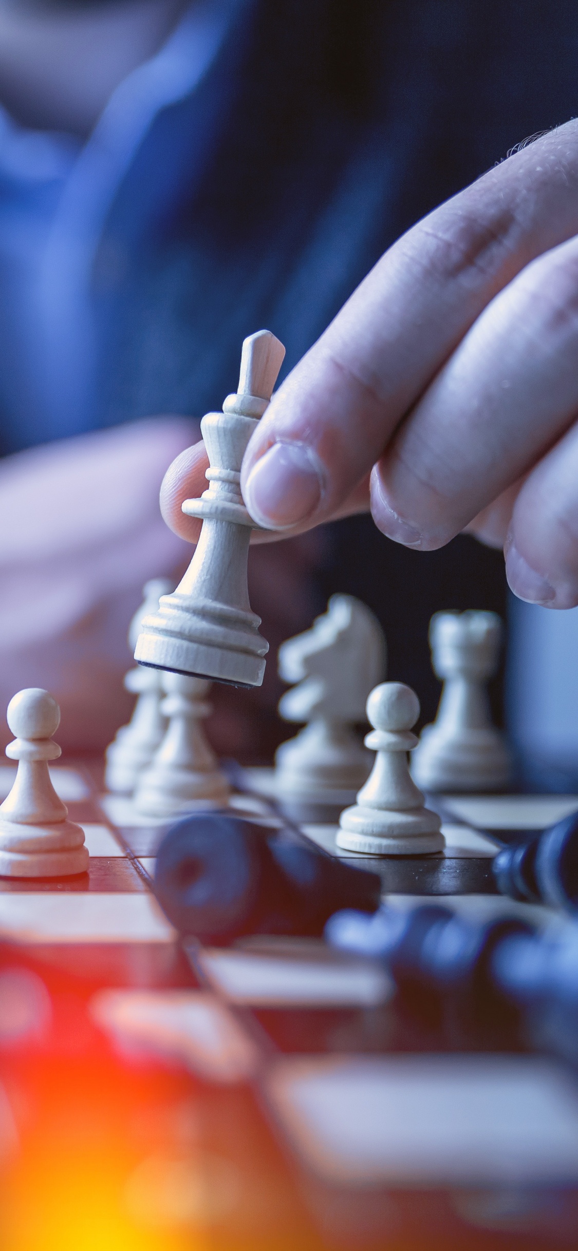 Person, Die Schachfigur in Tilt-Shift-Linse Hält. Wallpaper in 1125x2436 Resolution
