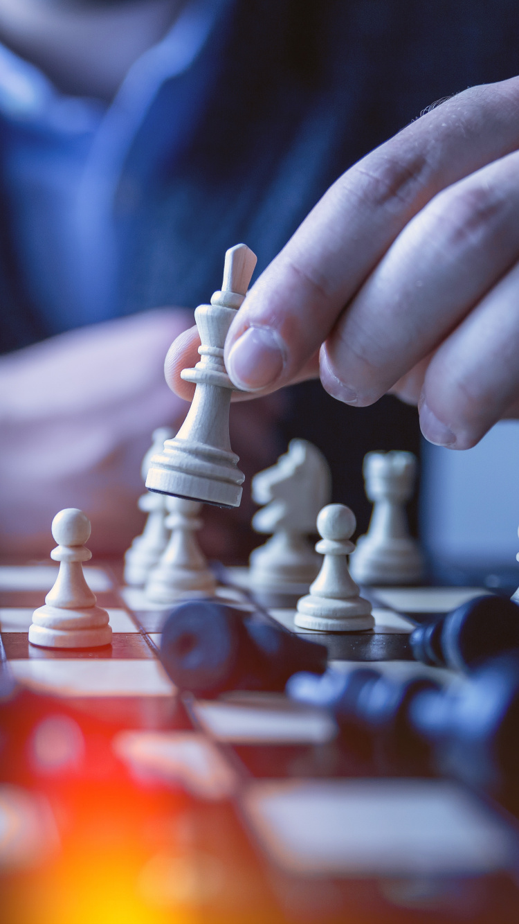 Person Holding Chess Piece in Tilt Shift Lens. Wallpaper in 750x1334 Resolution