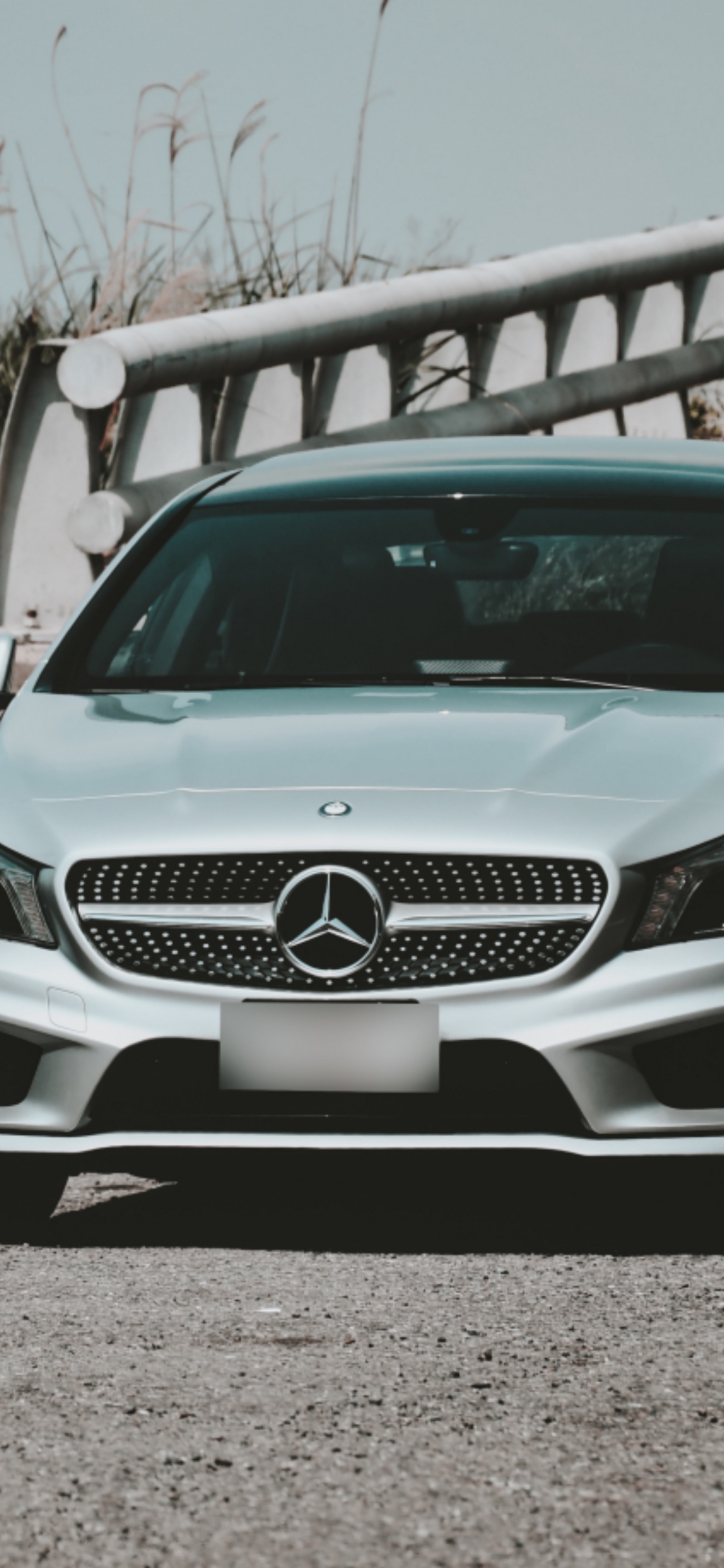 Weiße Mercedes-Benz C-Klasse Tagsüber Auf Grauem Sand Geparkt. Wallpaper in 1125x2436 Resolution