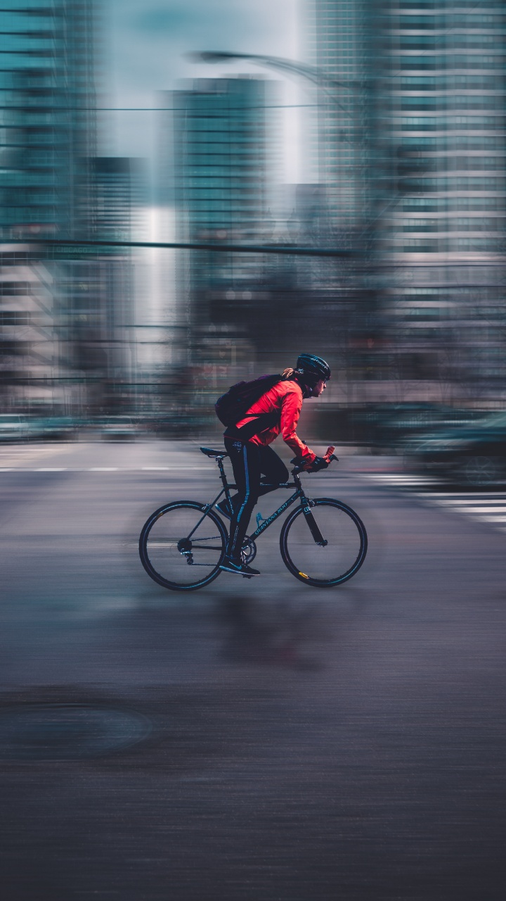 Mann in Roter Jacke, Der Tagsüber Fahrrad Auf Der Straße Fährt. Wallpaper in 720x1280 Resolution