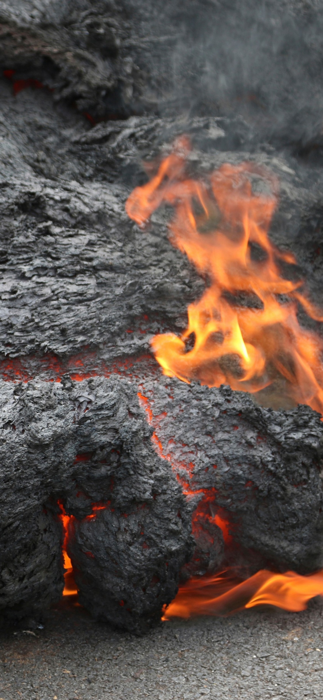 Schwarzes Und Rotes Feuer Auf Grauem Sand. Wallpaper in 1125x2436 Resolution