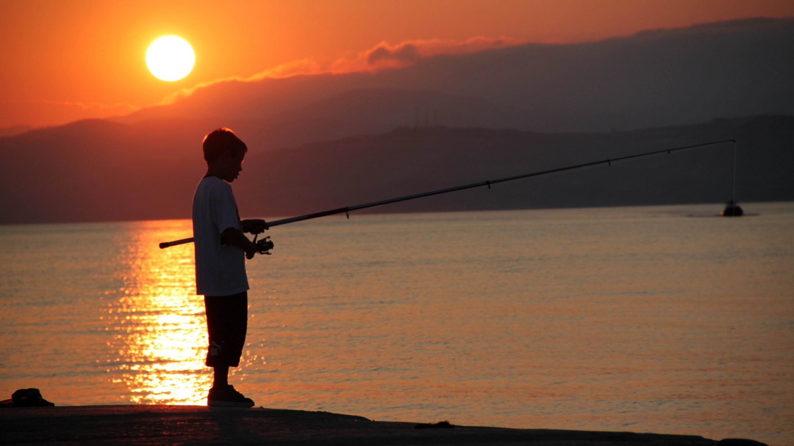 Hombre Con Camisa Blanca y Pantalón Negro Pescando en el Mar Durante la Puesta de Sol. Wallpaper in 2560x1440 Resolution