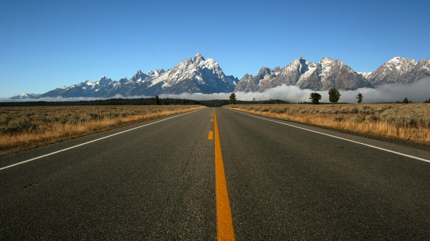 Gray Concrete Road Near Mountain Under Blue Sky During Daytime. Wallpaper in 1366x768 Resolution