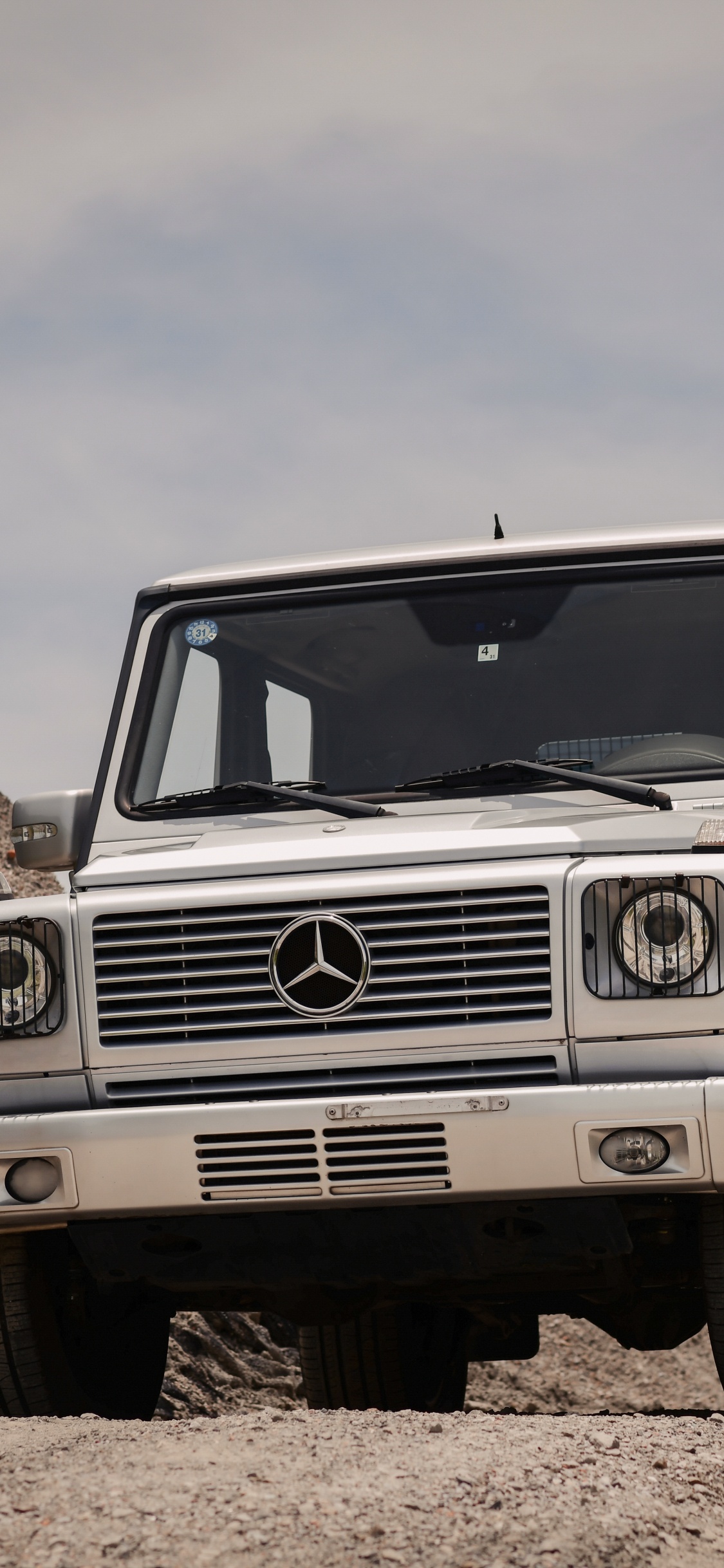 Weißer Jeep Wrangler Auf Braunem Felsigem Feld Unter Weißem Bewölktem Himmel Tagsüber. Wallpaper in 1125x2436 Resolution