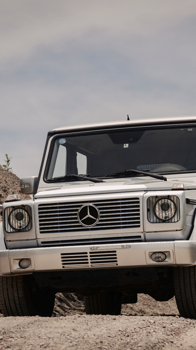 White Jeep Wrangler on Brown Rocky Field Under White Cloudy Sky During Daytime. Wallpaper in 750x1334 Resolution