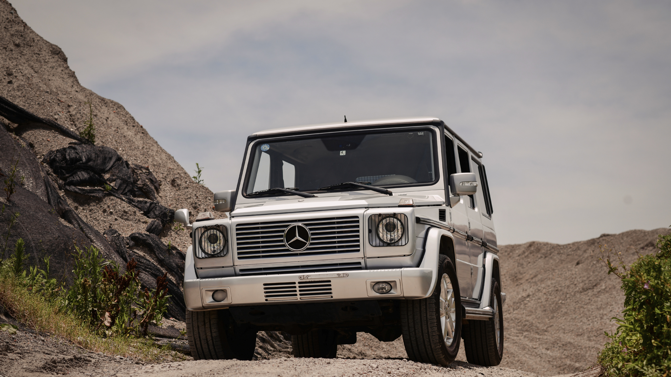 Jeep Wrangler Blanc Sur Champ Rocheux Brun Sous Ciel Nuageux Blanc Pendant la Journée. Wallpaper in 2560x1440 Resolution