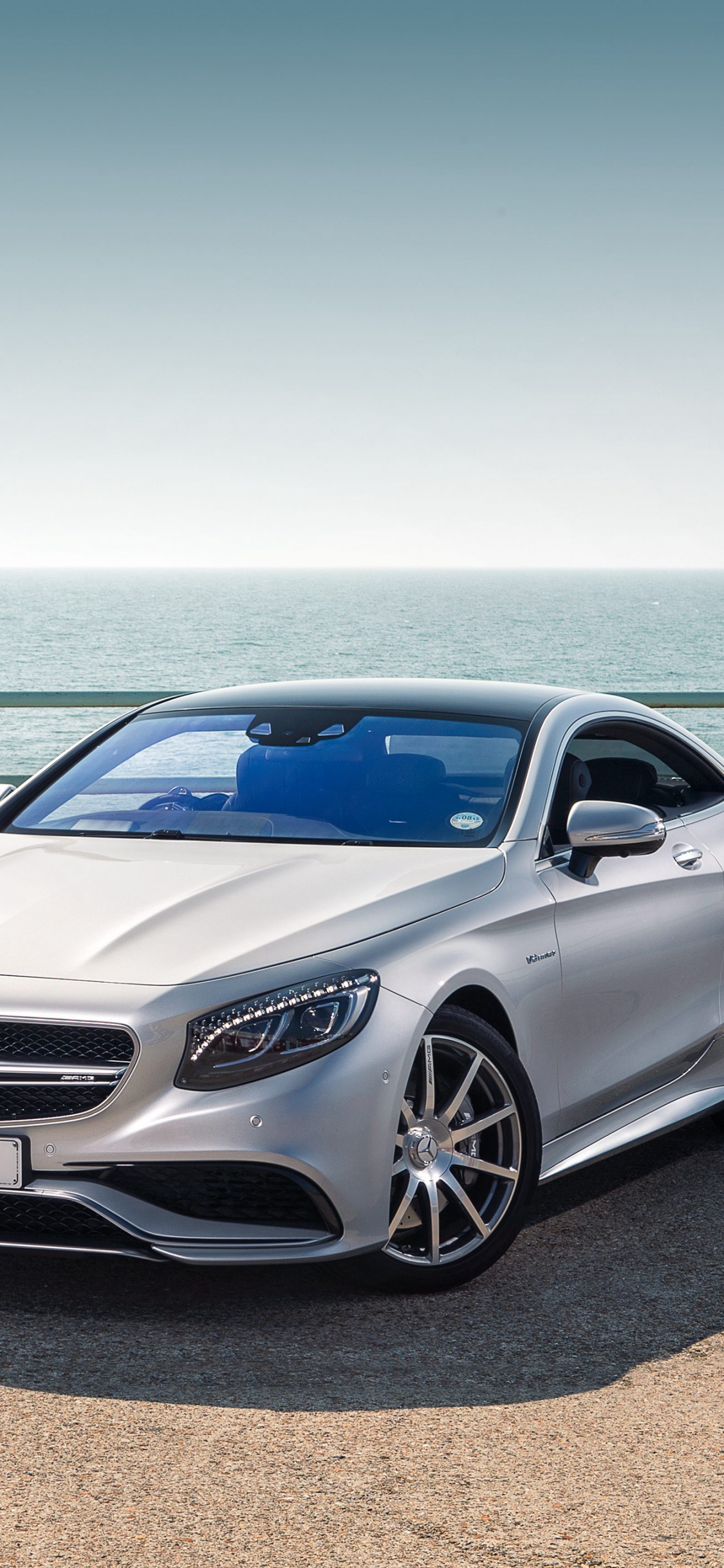 Silver Mercedes Benz Coupé Garé Sur du Sable Brun Près de la Mer Pendant la Journée. Wallpaper in 1125x2436 Resolution