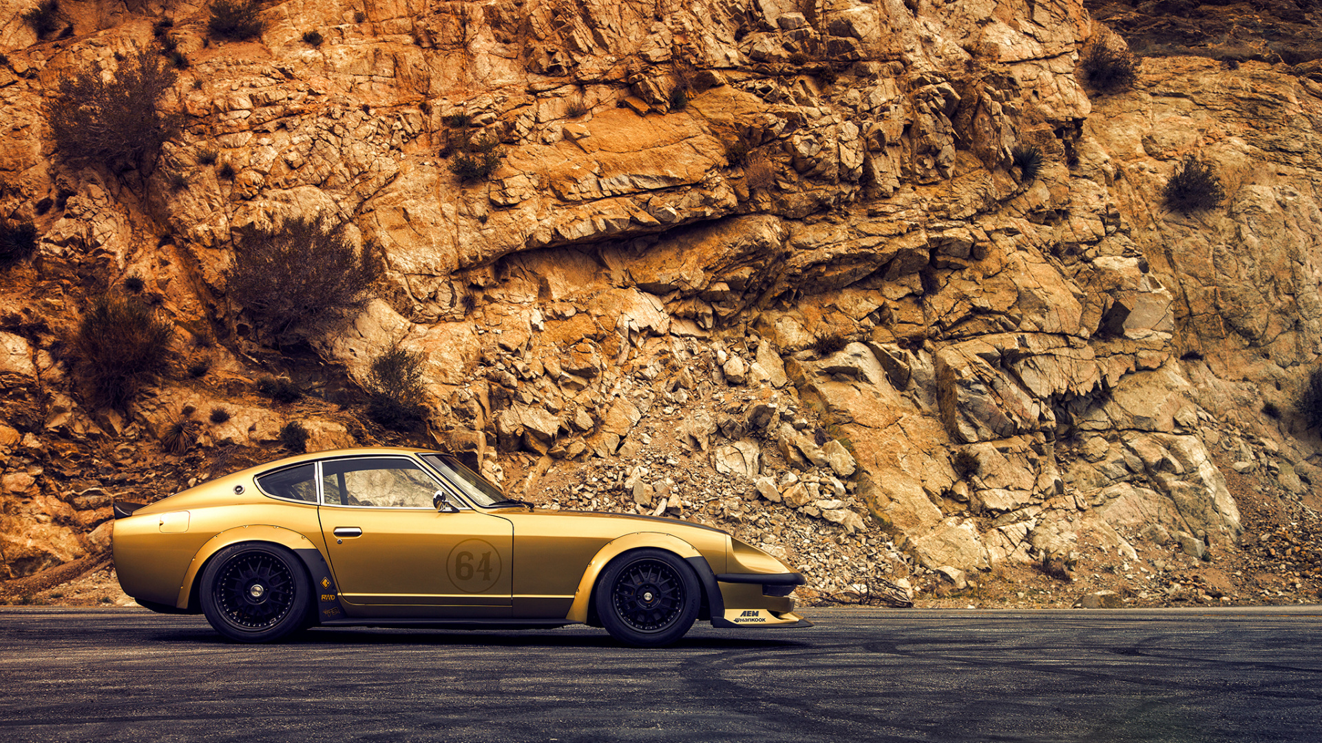 Yellow Coupe Parked Beside Brown Rock Formation During Daytime. Wallpaper in 1920x1080 Resolution