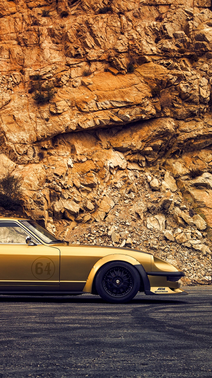 Yellow Coupe Parked Beside Brown Rock Formation During Daytime. Wallpaper in 720x1280 Resolution