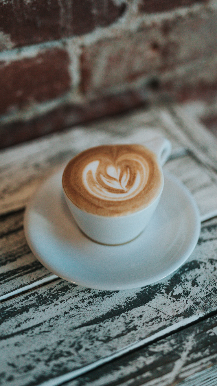 Weiße Keramiktasse Mit Untertasse Auf Dem Tisch. Wallpaper in 750x1334 Resolution