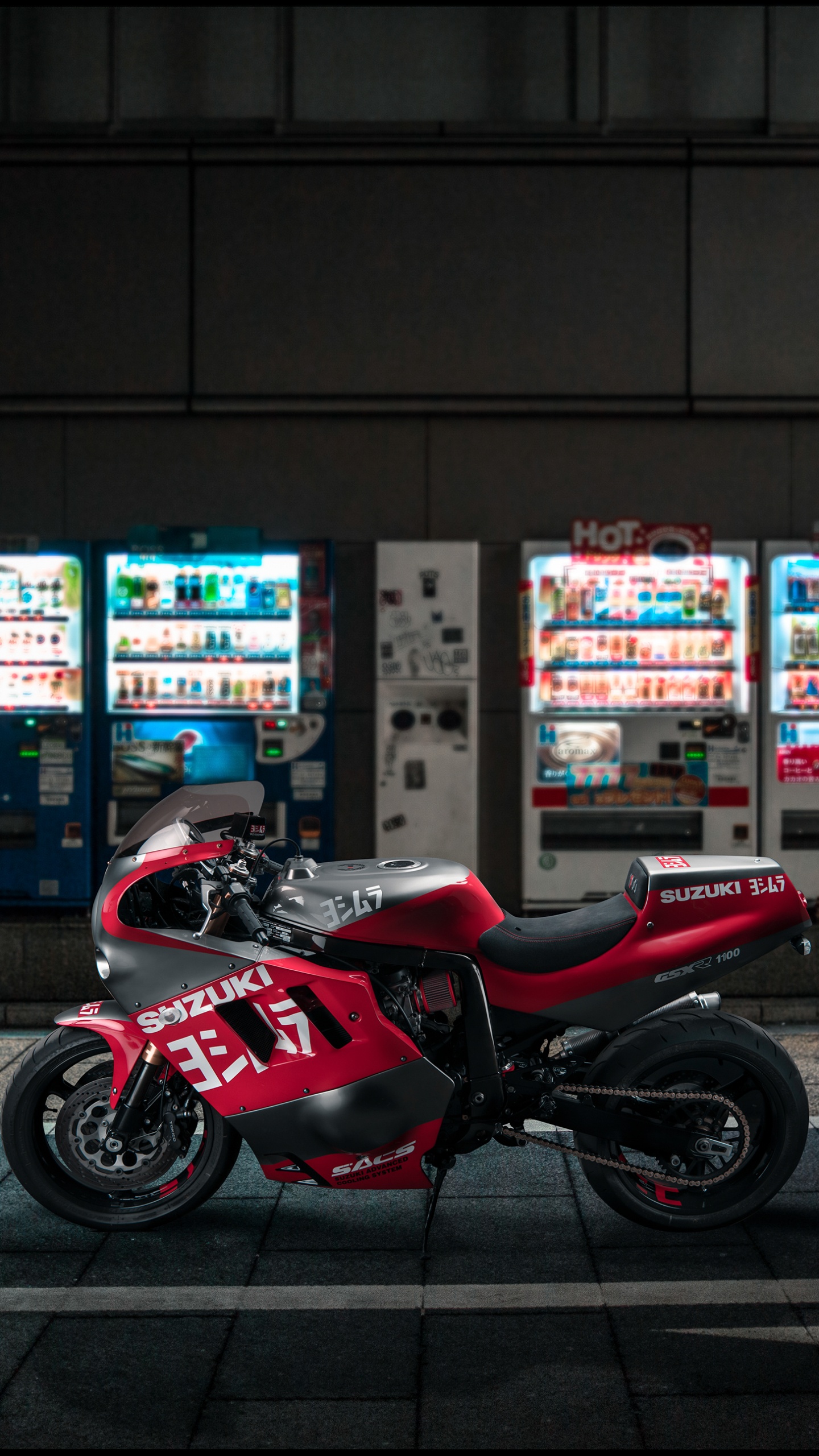 Bicicleta Deportiva Roja y Negra Estacionada en la Acera Durante la Noche. Wallpaper in 1440x2560 Resolution