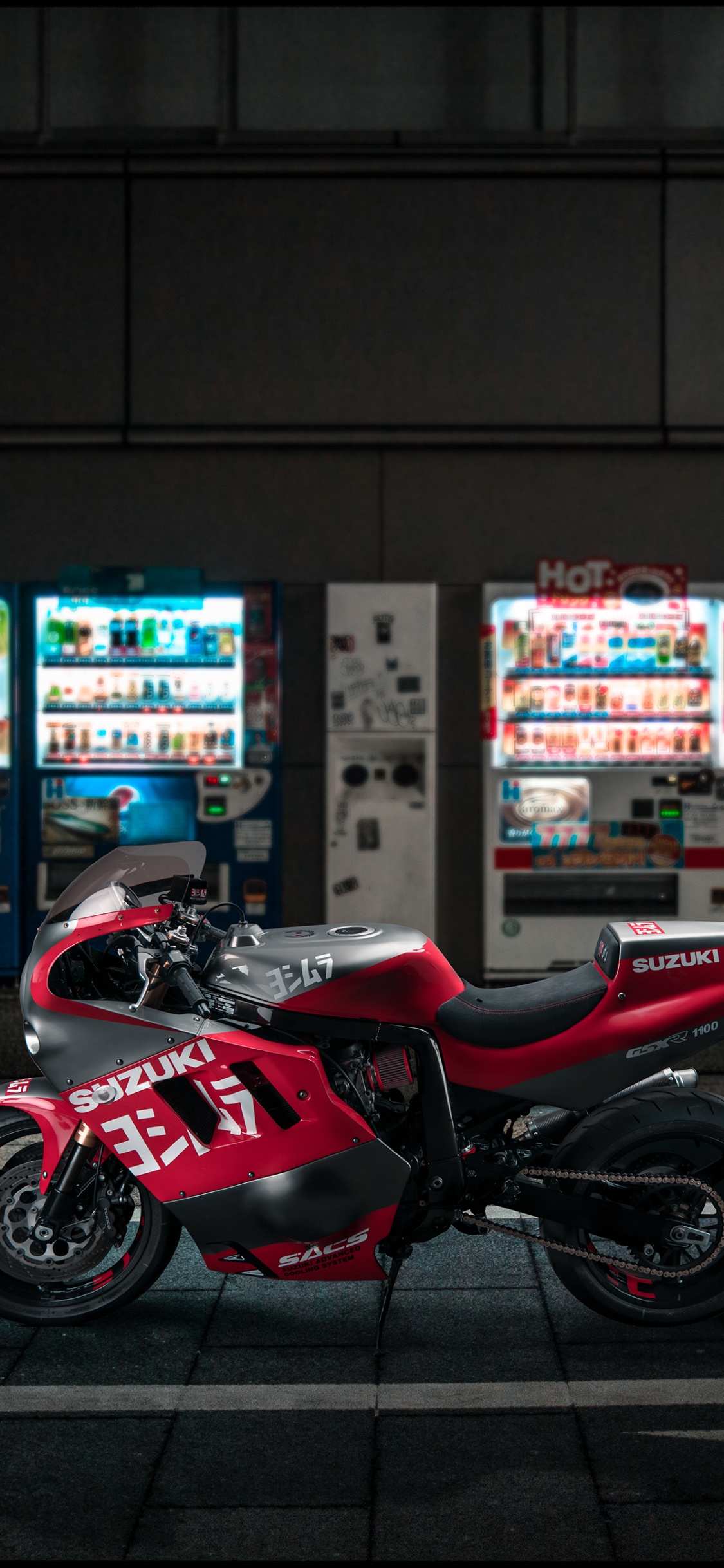 Rotes Und Schwarzes Sportfahrrad, Das Nachts Auf Dem Bürgersteig Geparkt Ist. Wallpaper in 1125x2436 Resolution