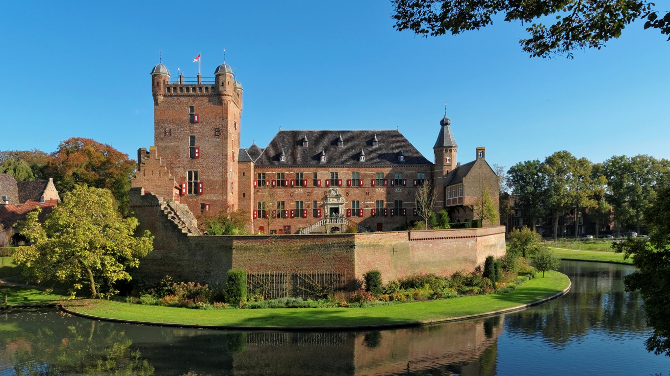 Braunes Betongebäude in Der Nähe Von Grünen Bäumen Und Fluss Unter Blauem Himmel Tagsüber. Wallpaper in 1366x768 Resolution