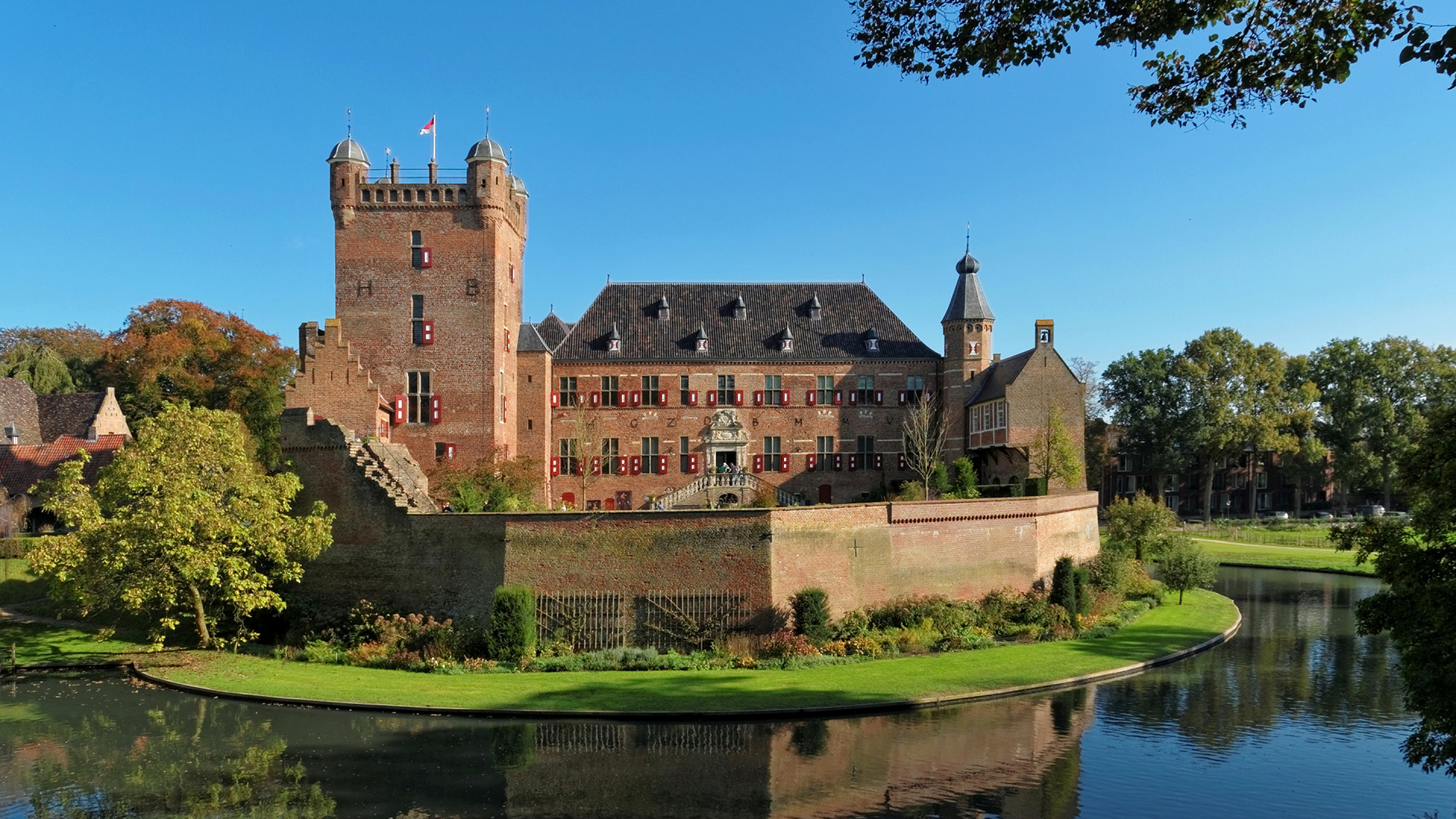 Braunes Betongebäude in Der Nähe Von Grünen Bäumen Und Fluss Unter Blauem Himmel Tagsüber. Wallpaper in 1920x1080 Resolution