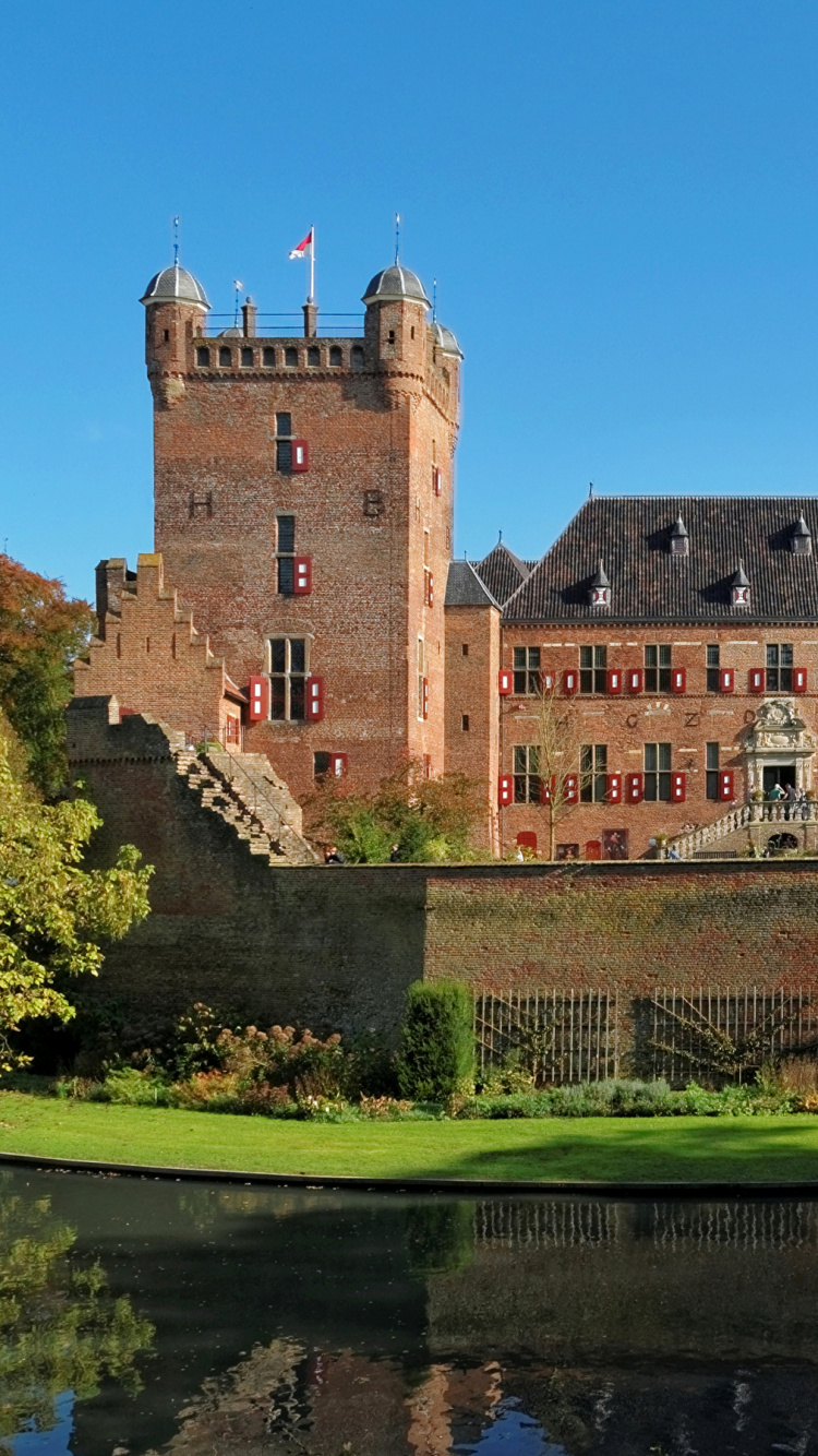 Braunes Betongebäude in Der Nähe Von Grünen Bäumen Und Fluss Unter Blauem Himmel Tagsüber. Wallpaper in 750x1334 Resolution