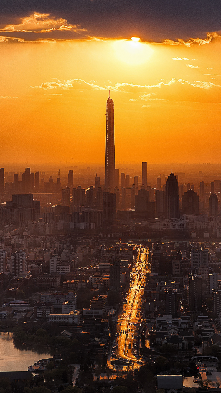 Skyline Der Stadt Bei Sonnenuntergang Mit Gewässer With. Wallpaper in 750x1334 Resolution