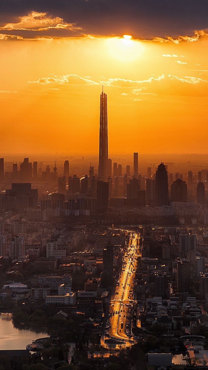 City Skyline During Sunset With Body of Water. Wallpaper in 720x1280 Resolution