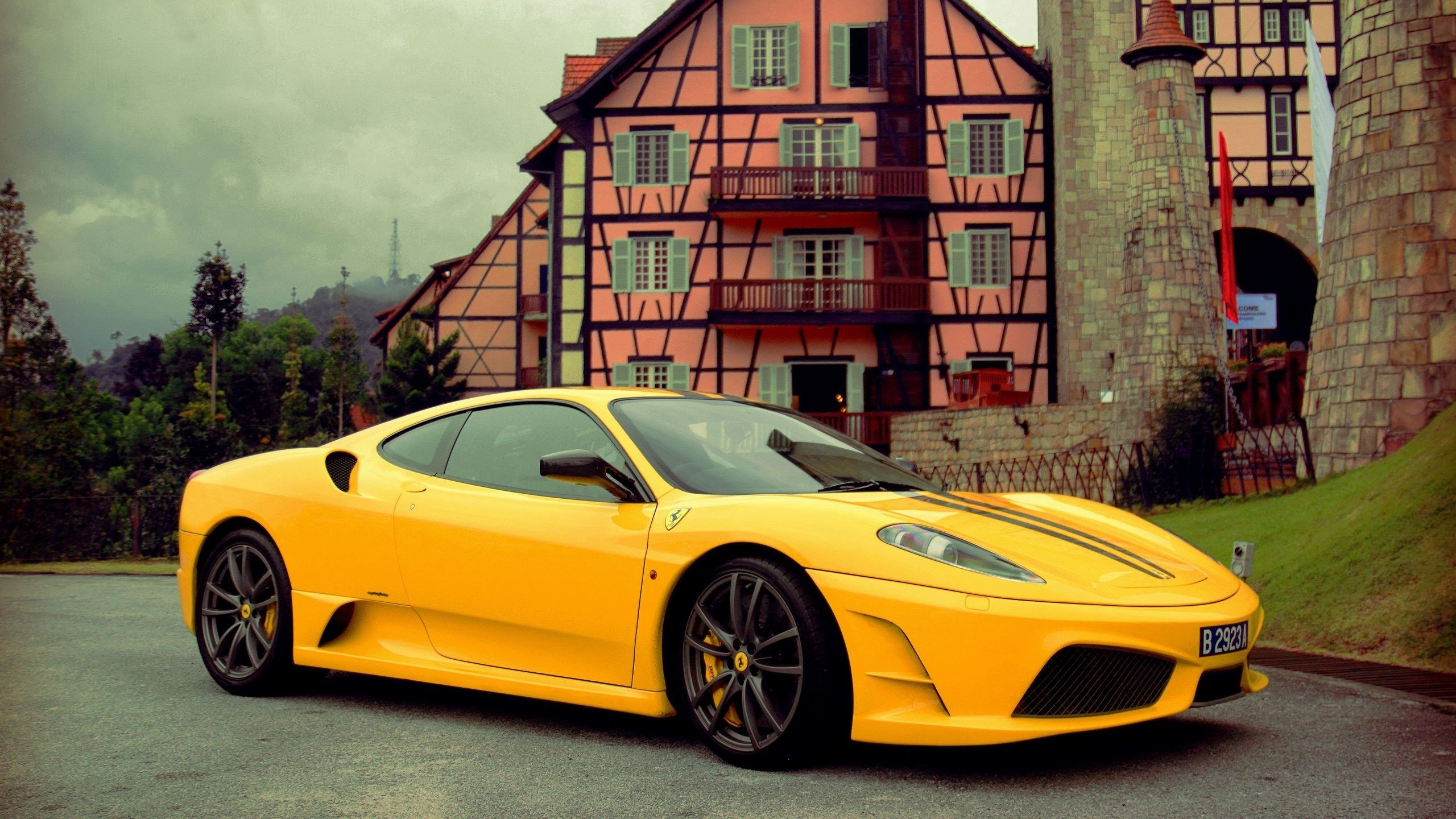 Yellow Ferrari 458 Italia Parked Beside Brown Brick Building. Wallpaper in 2560x1440 Resolution