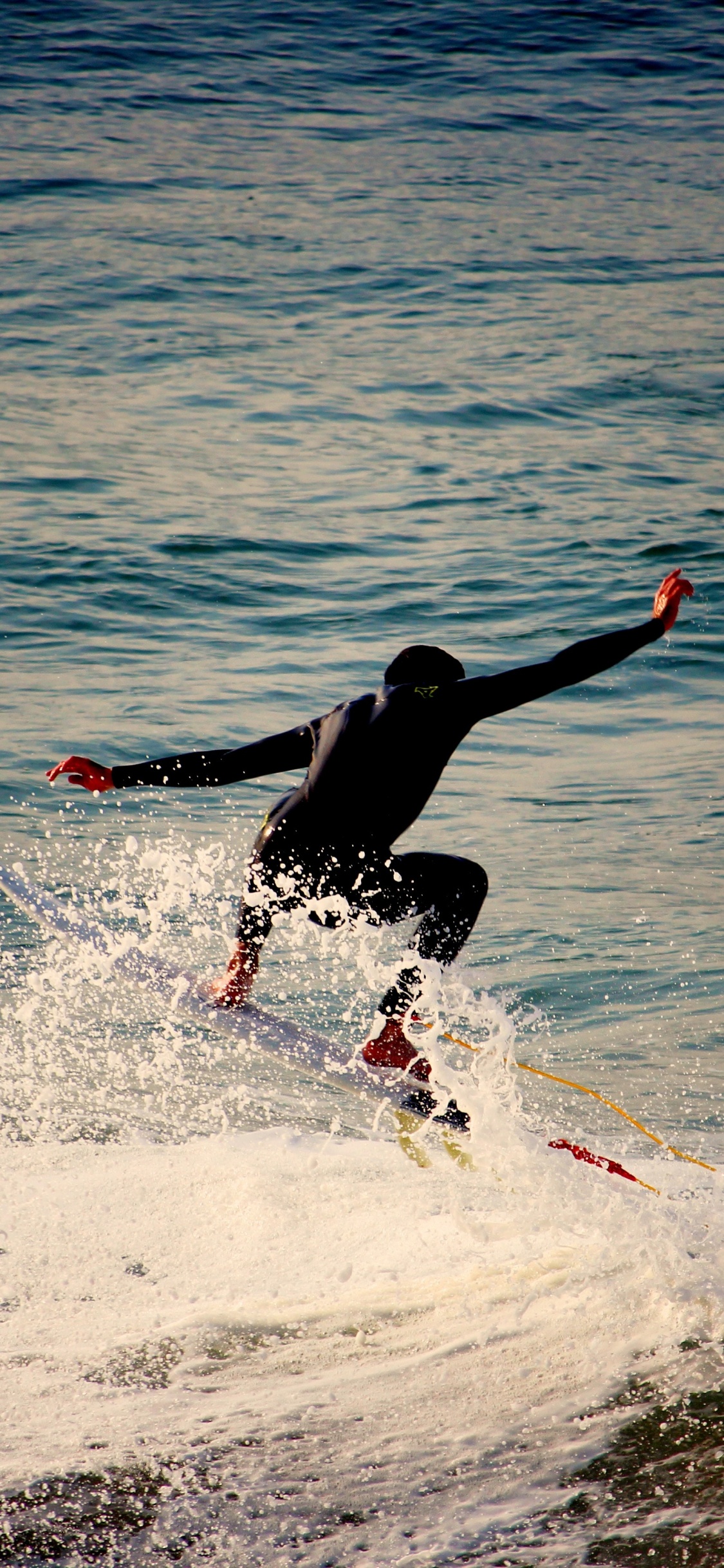 Homme Surfant Sur Les Vagues de la Mer Pendant la Journée. Wallpaper in 1125x2436 Resolution