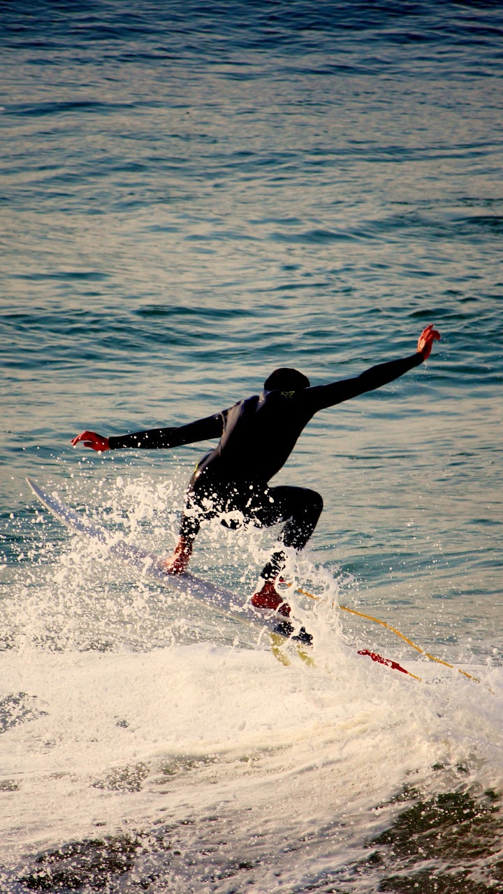 Hombre Surfeando Sobre Las Olas Del Mar Durante el Día. Wallpaper in 720x1280 Resolution