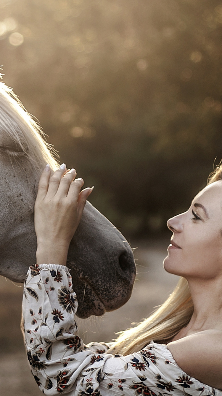 Femme en Chemise Fleurie Noire et Blanche à Côté D'un Cheval Blanc Pendant la Journée. Wallpaper in 750x1334 Resolution