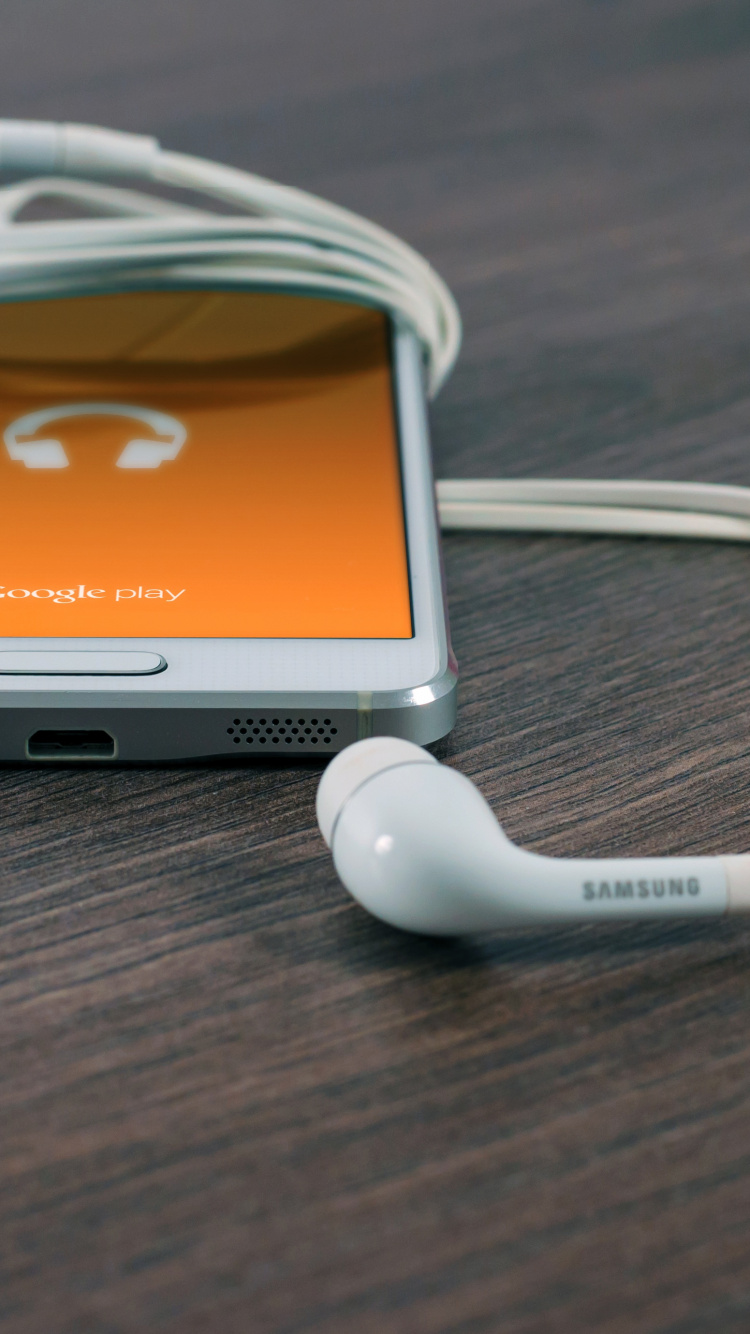 Weißes Samsung Android-Smartphone Mit Weißen Ohrhörern. Wallpaper in 750x1334 Resolution