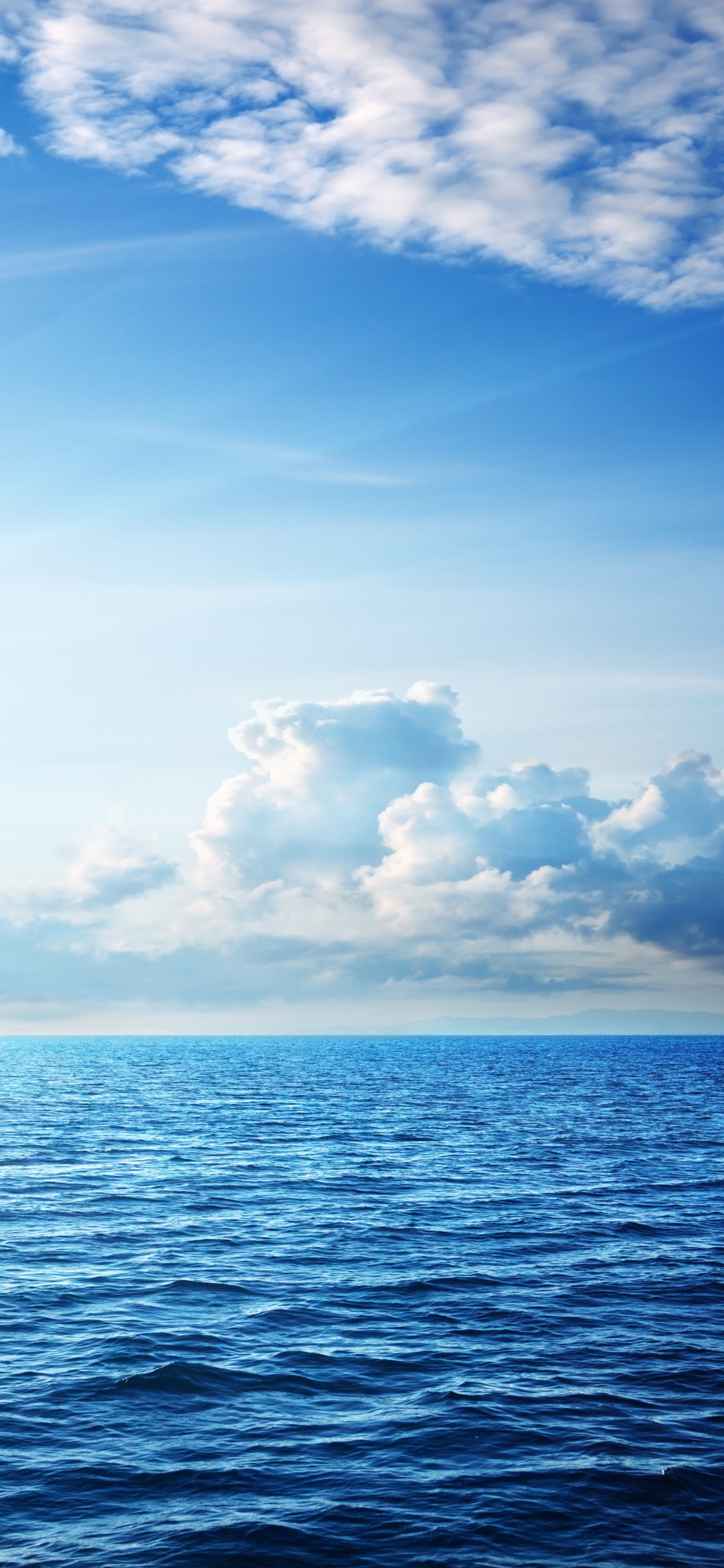 Blue Sea Under Blue Sky and White Clouds During Daytime. Wallpaper in 1125x2436 Resolution