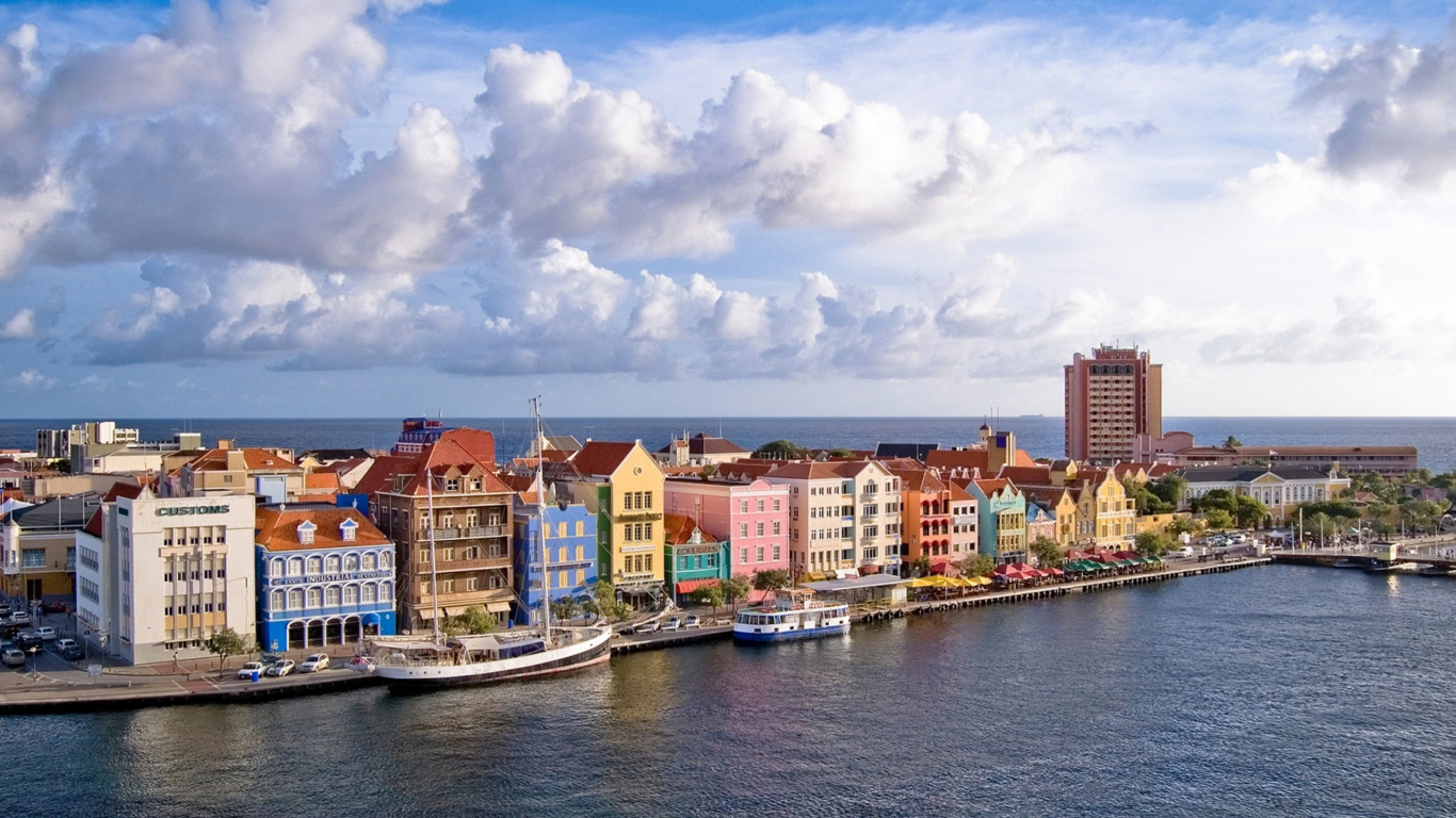 White and Brown Concrete Buildings Near Body of Water Under Blue and White Cloudy Sky During. Wallpaper in 1366x768 Resolution