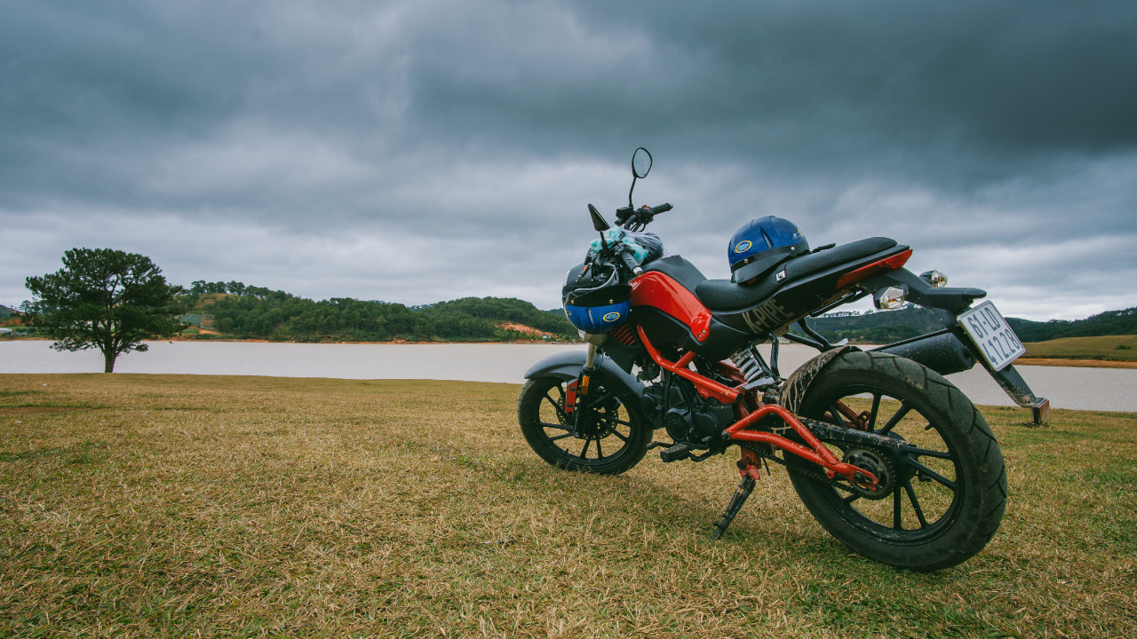 Red and Black Standard Motorcycle on Brown Field Under Gray Cloudy Sky. Wallpaper in 1280x720 Resolution