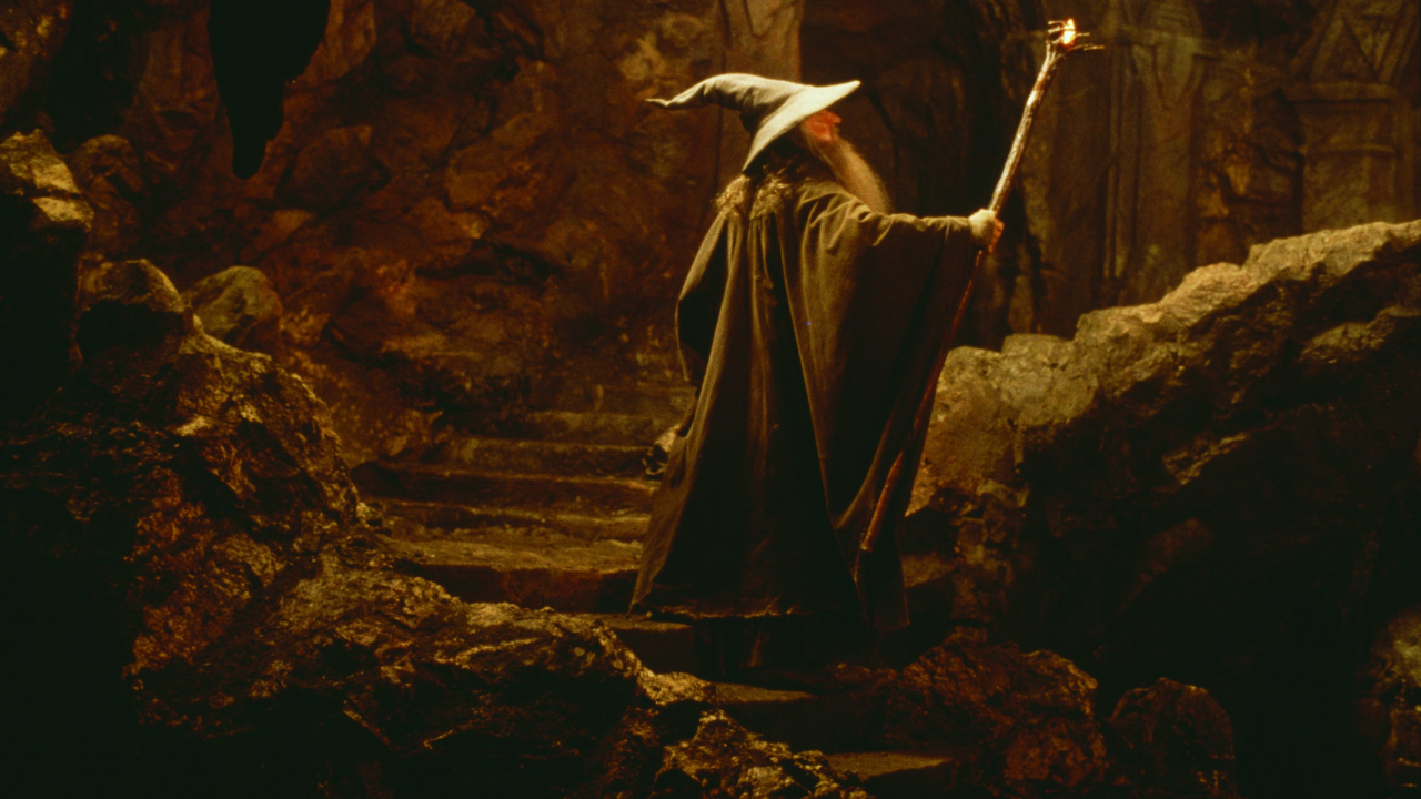 Femme en Robe Noire Debout Sur Brown Rock. Wallpaper in 1280x720 Resolution