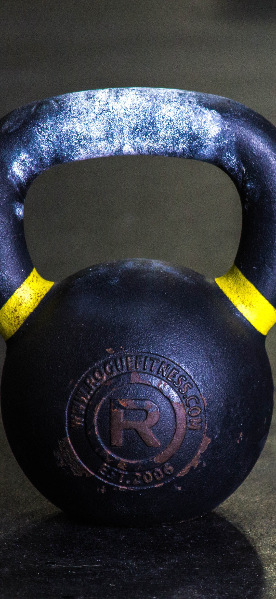 Black Kettle Bell on Brown Wooden Table. Wallpaper in 1125x2436 Resolution