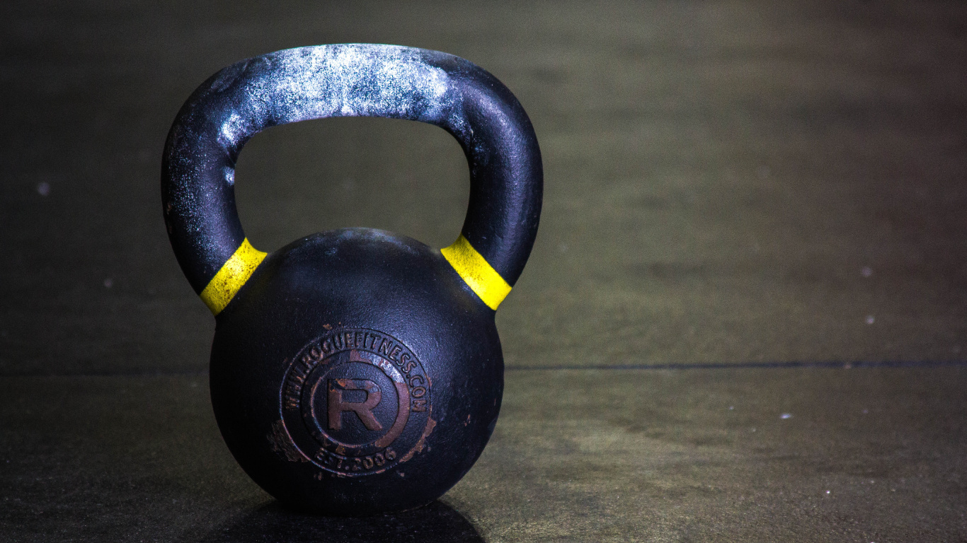 Black Kettle Bell on Brown Wooden Table. Wallpaper in 1366x768 Resolution