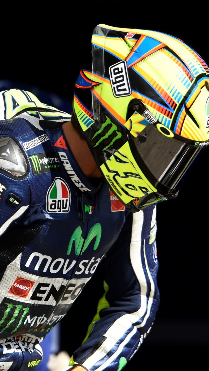 Mann Mit Gelbem Und Blauem Helm, Der Auf Gelbem Und Schwarzem Motorrad Fährt. Wallpaper in 720x1280 Resolution