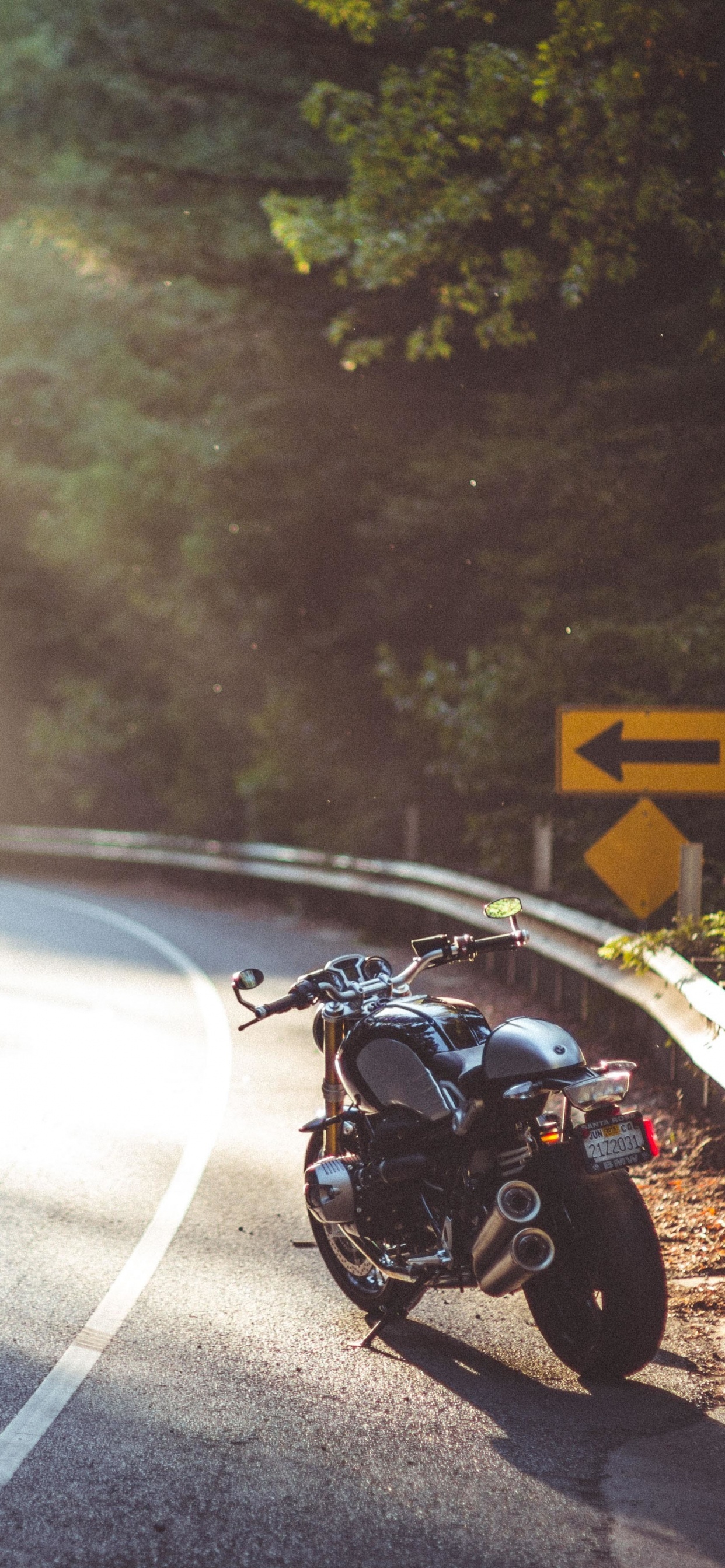 Schwarzes Motorrad Tagsüber Unterwegs. Wallpaper in 1242x2688 Resolution