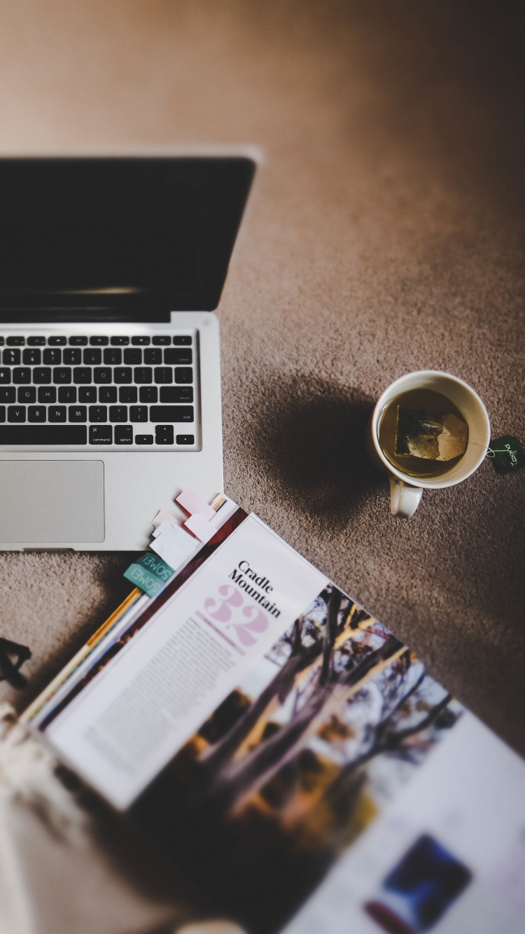 MacBook Pro Neben Schwarzem Smartphone Und Schwarzer Sonnenbrille. Wallpaper in 750x1334 Resolution