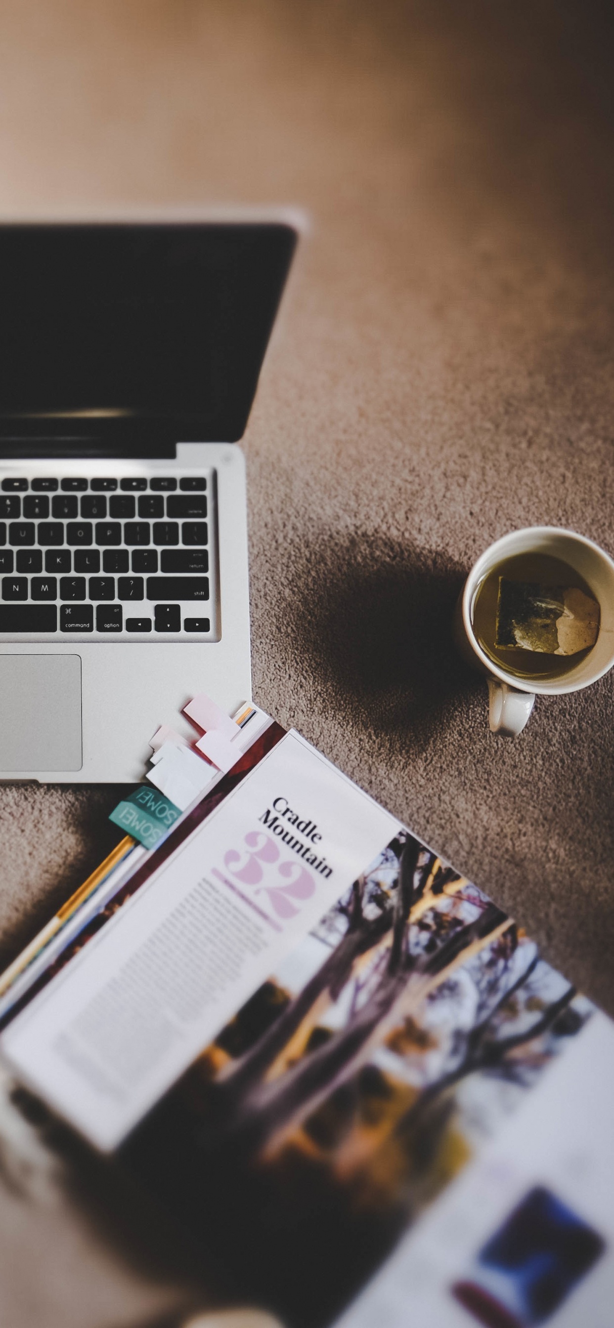 Macbook Pro al Lado de un Teléfono Inteligente Negro y Gafas de Sol Negras. Wallpaper in 1242x2688 Resolution