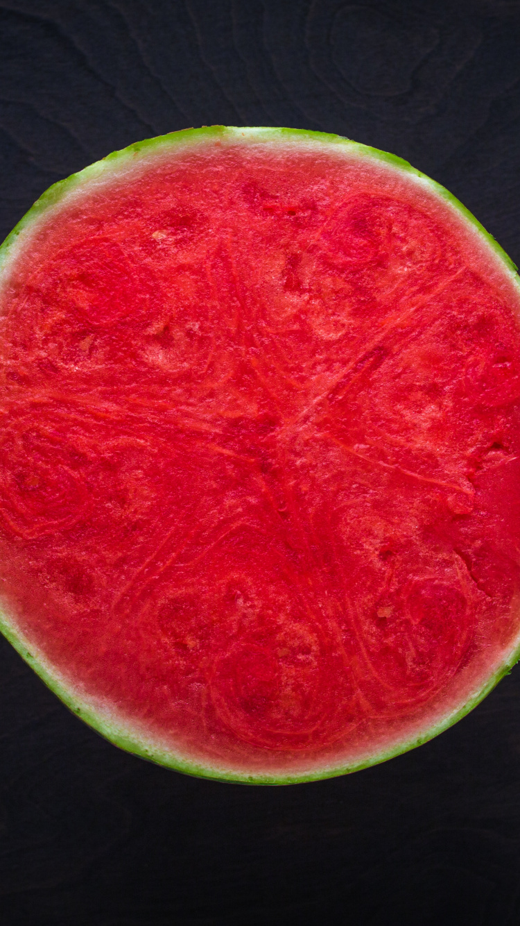 Sliced Watermelon on Black Wooden Table. Wallpaper in 750x1334 Resolution