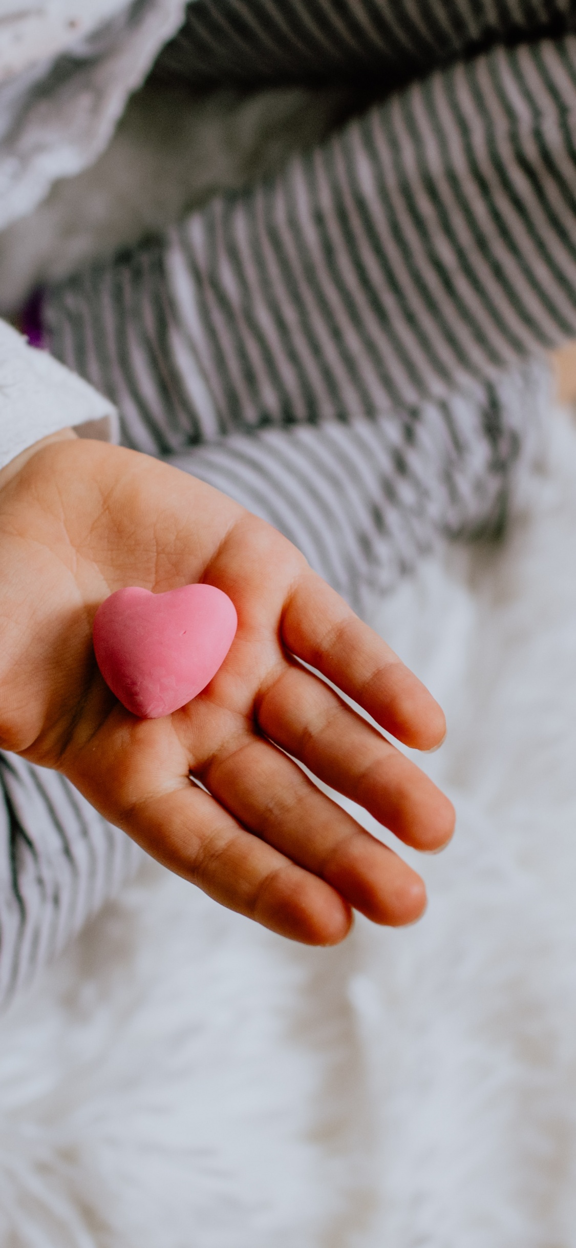 Person im Weiß-grau Gestreiften Langarmshirt Mit Oranger Maniküre. Wallpaper in 1125x2436 Resolution