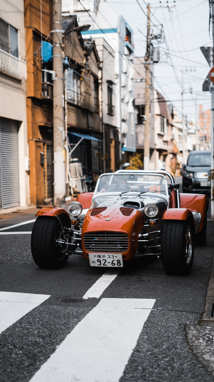 Orange and Black Car on Road During Daytime. Wallpaper in 750x1334 Resolution