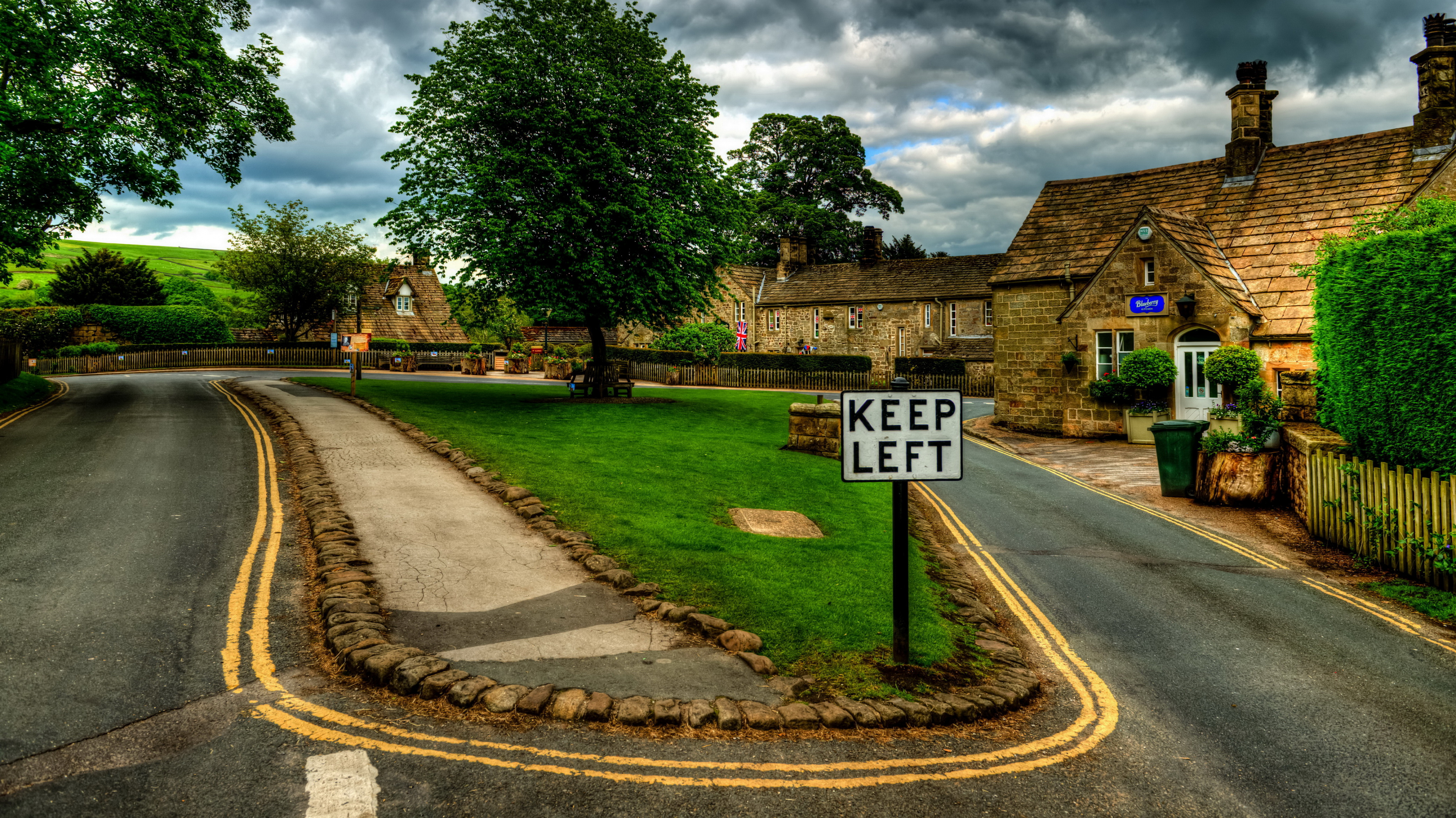 White and Black Road Sign Near Green Trees Under Cloudy Sky During Daytime. Wallpaper in 3840x2160 Resolution
