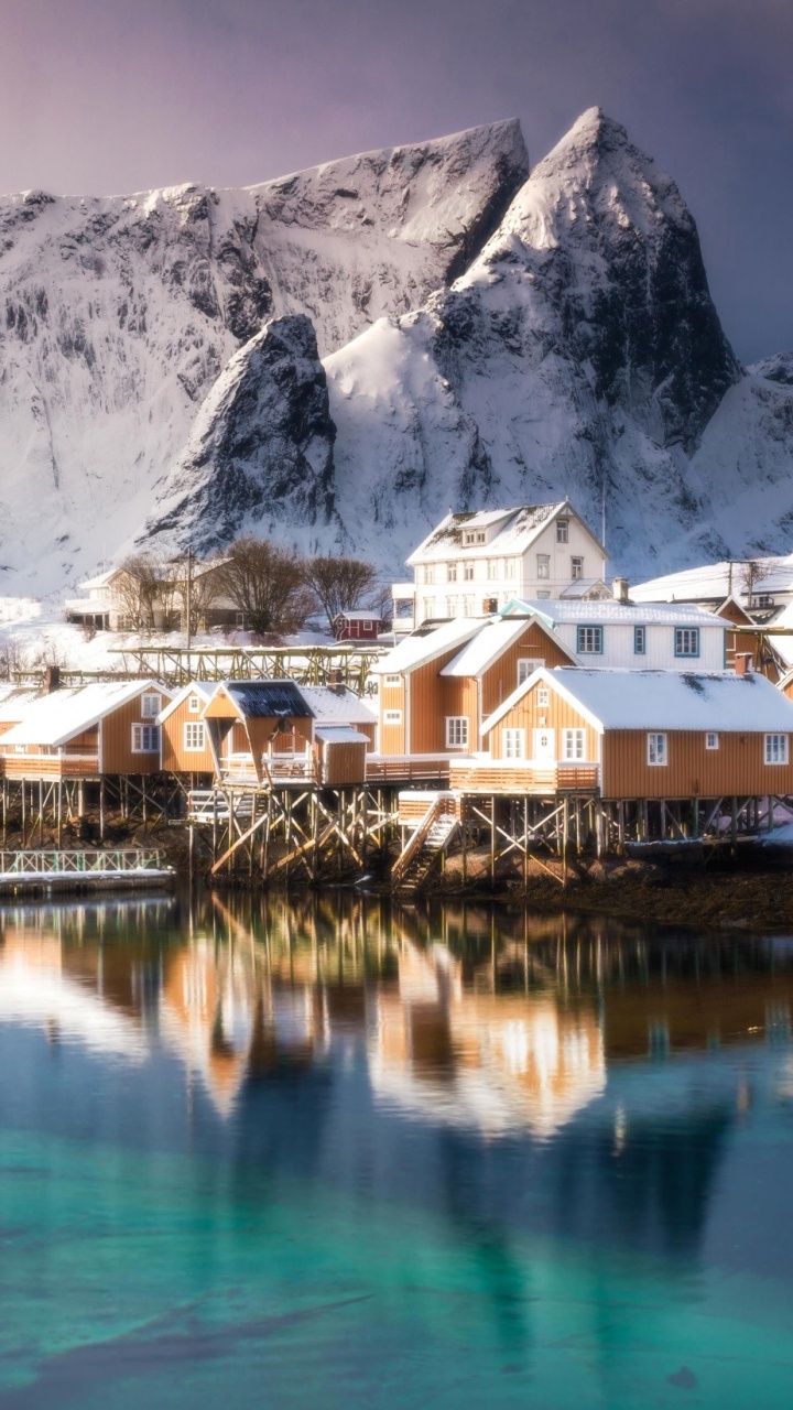 Maisons Près D'un Plan D'eau et D'une Montagne Couverte de Neige Pendant la Journée. Wallpaper in 720x1280 Resolution