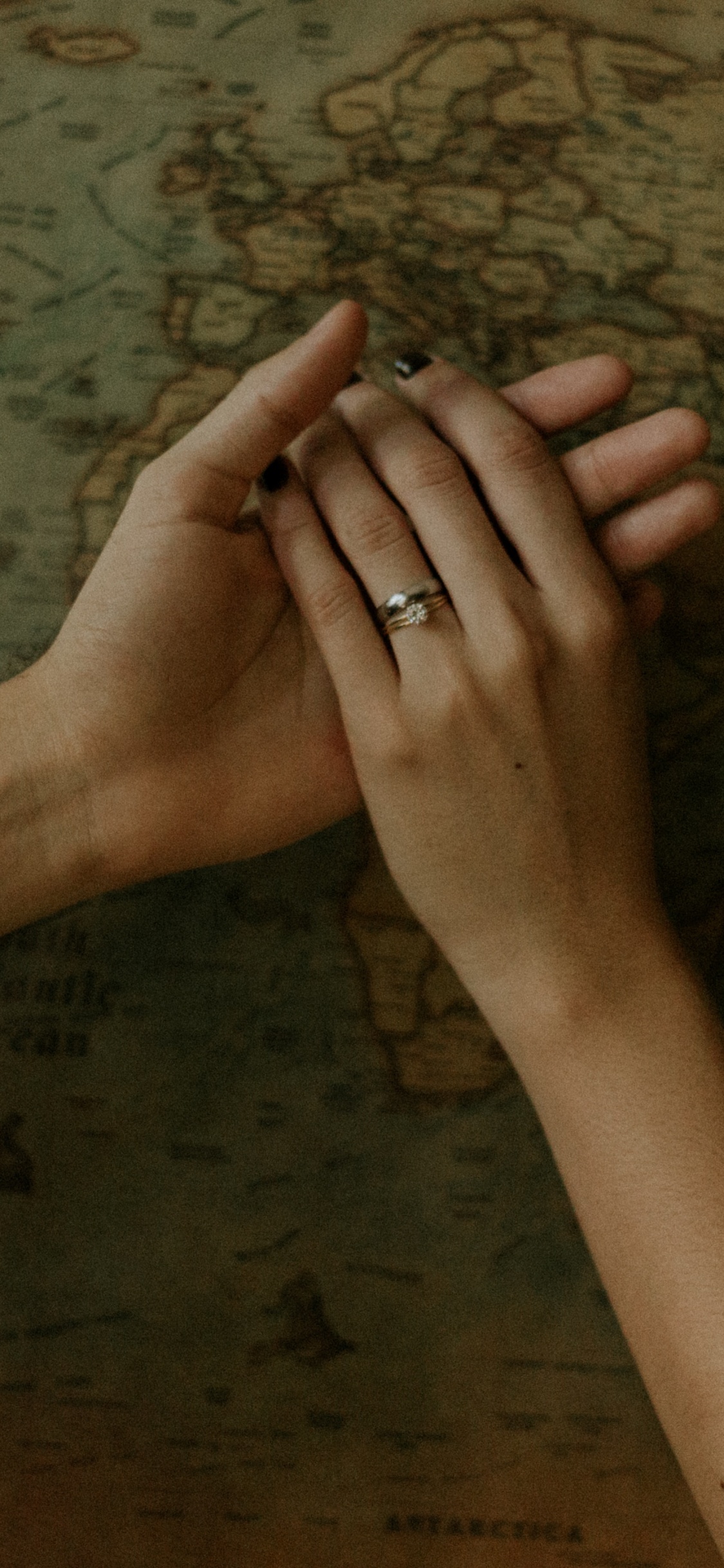 Persons Left Hand on Brown Wooden Surface. Wallpaper in 1125x2436 Resolution