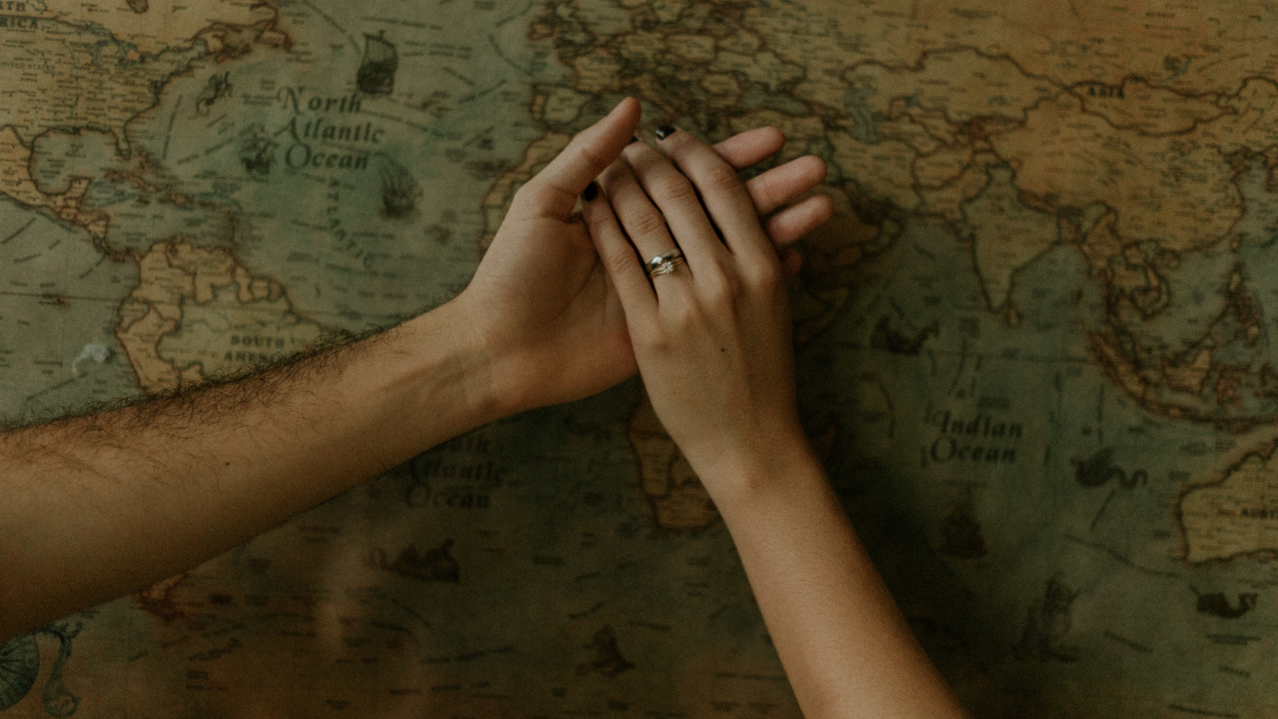 Persons Left Hand on Brown Wooden Surface. Wallpaper in 2560x1440 Resolution