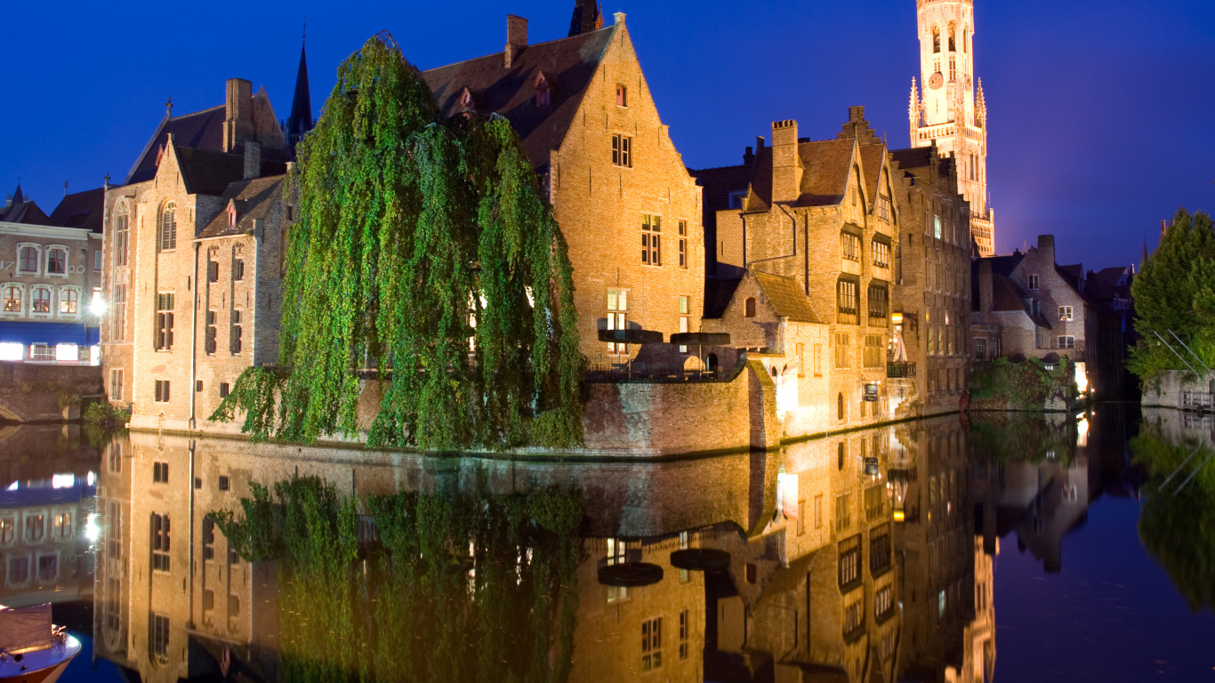 Brown Concrete Building Near Green Trees and Water During Daytime. Wallpaper in 1366x768 Resolution