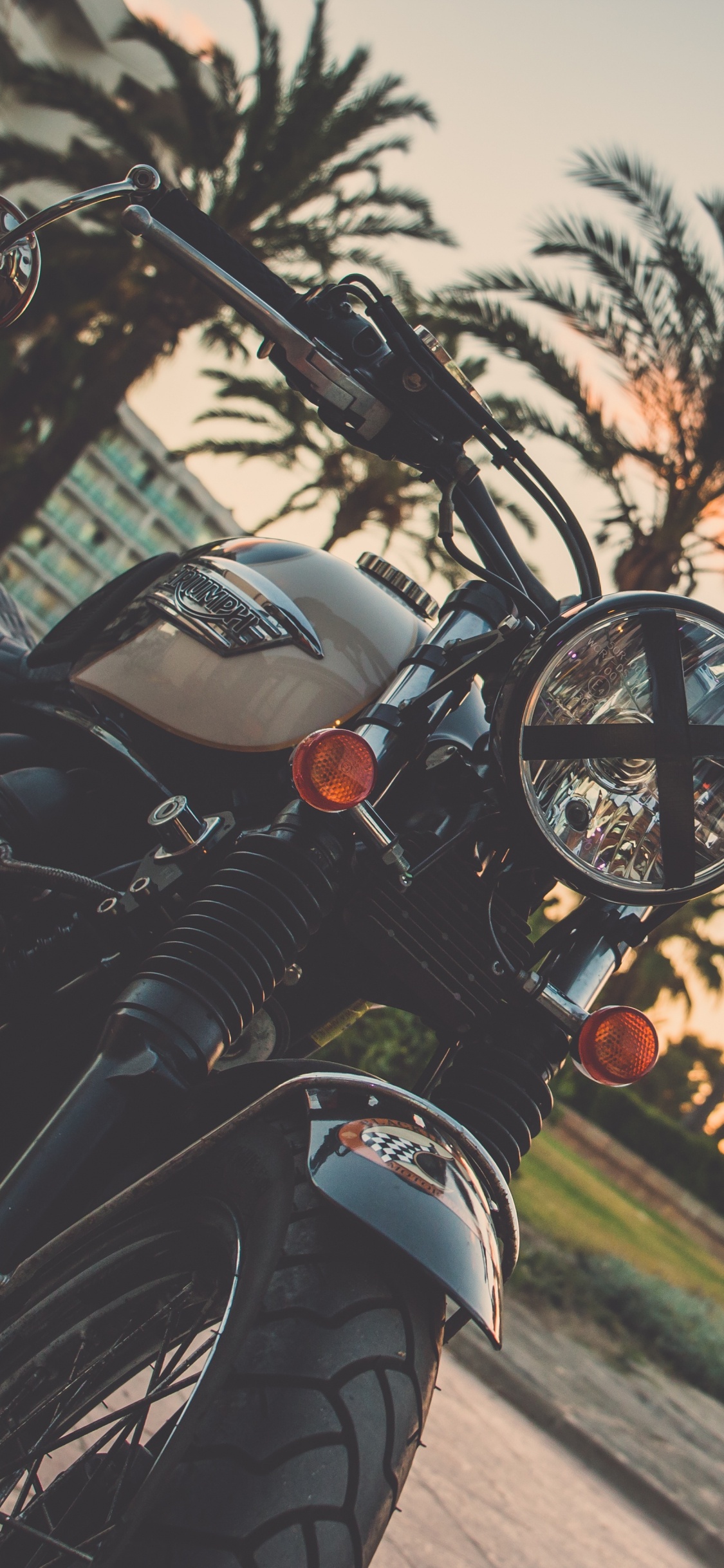 Motocicleta Negra Estacionada en la Carretera Durante la Puesta de Sol. Wallpaper in 1125x2436 Resolution