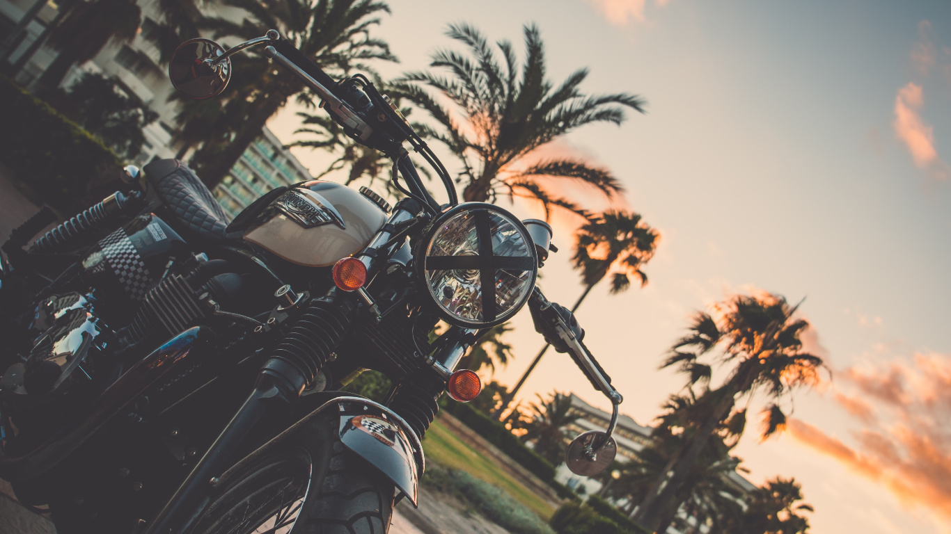Motocicleta Negra Estacionada en la Carretera Durante la Puesta de Sol. Wallpaper in 1366x768 Resolution