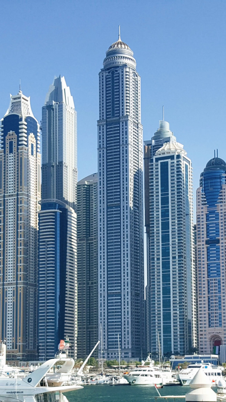 Immeubles de Grande Hauteur Blancs et Bleus Près D'un Plan D'eau Pendant la Journée. Wallpaper in 750x1334 Resolution